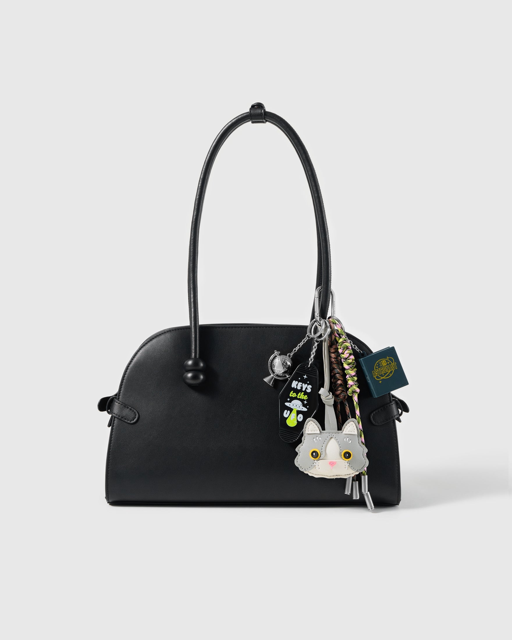 Silver Cat Lucky Stack Charm attached to a structured handbag to show the complete design