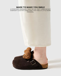 Poodle brown suede clogs worn on foot, showing the medium brown curly plush face and slip-on shape