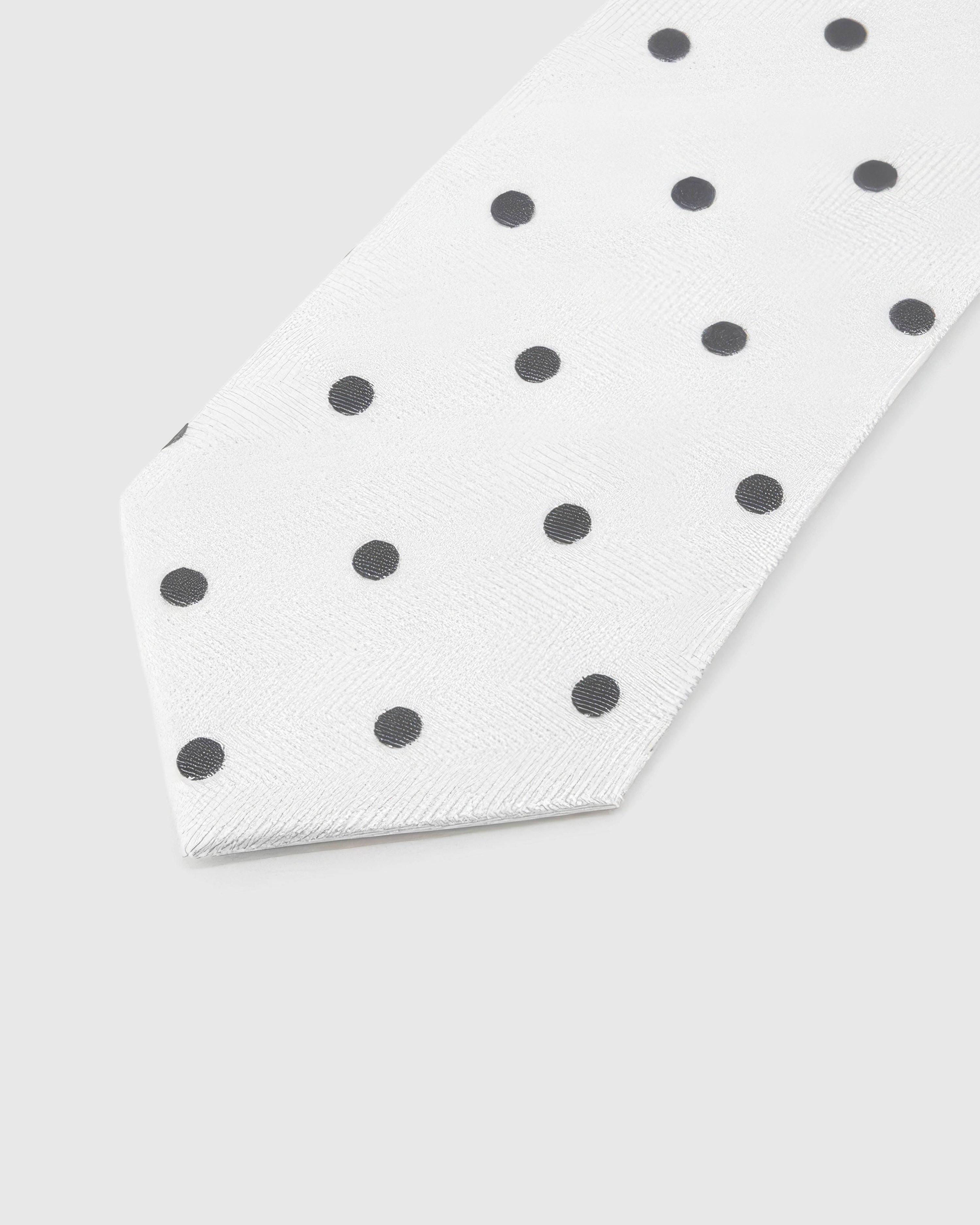 Pearl Onyx Dot Tie blade detail showing hand-embroidered onyx polka dots and silk texture by STICKYZOO