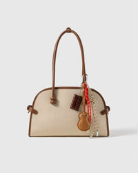 Chocolate Peanut Stack Charm attached to a structured handbag to show the complete design