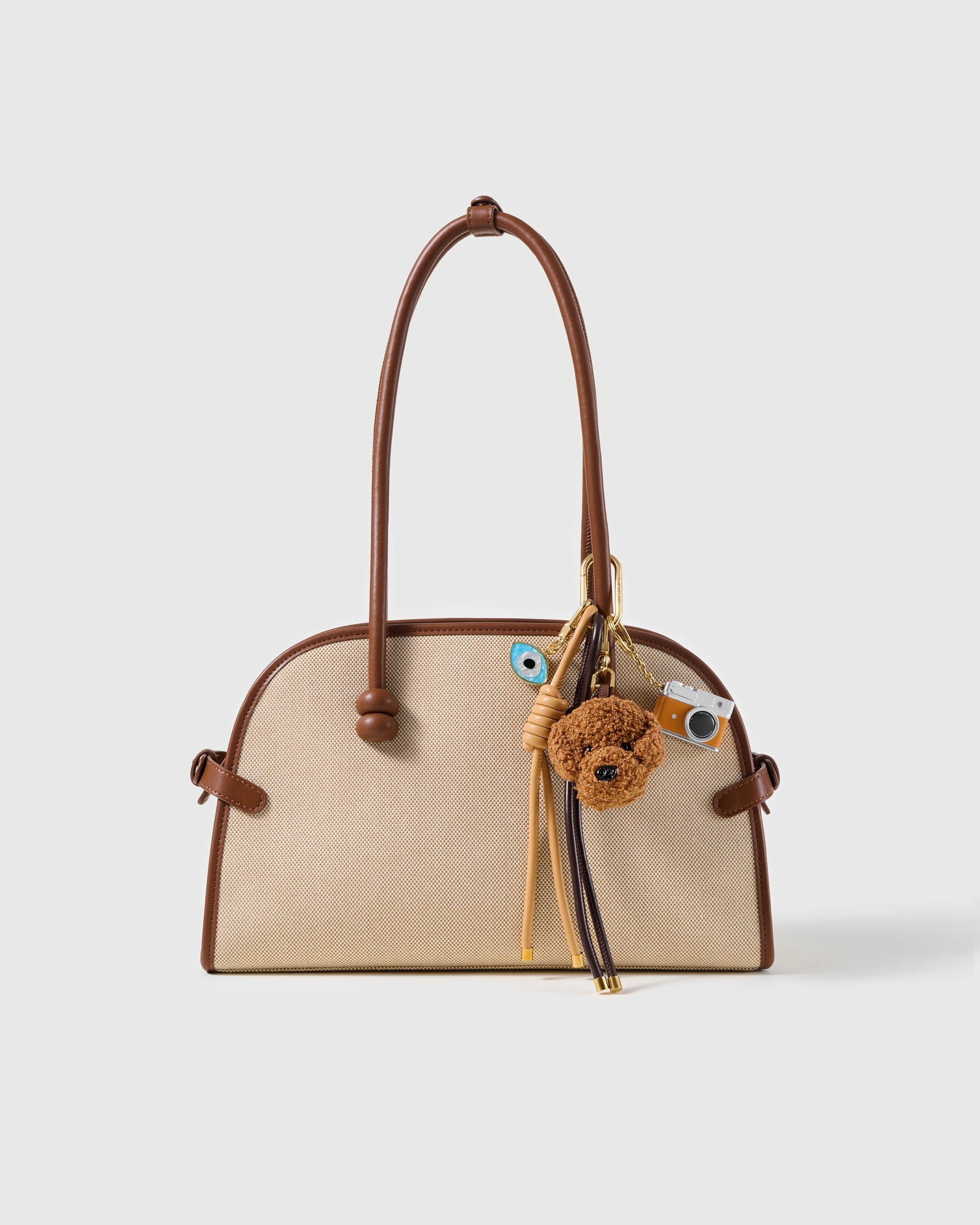 Poodle Evil Eye Camera Stack Charm attached to a structured handbag to show the complete design