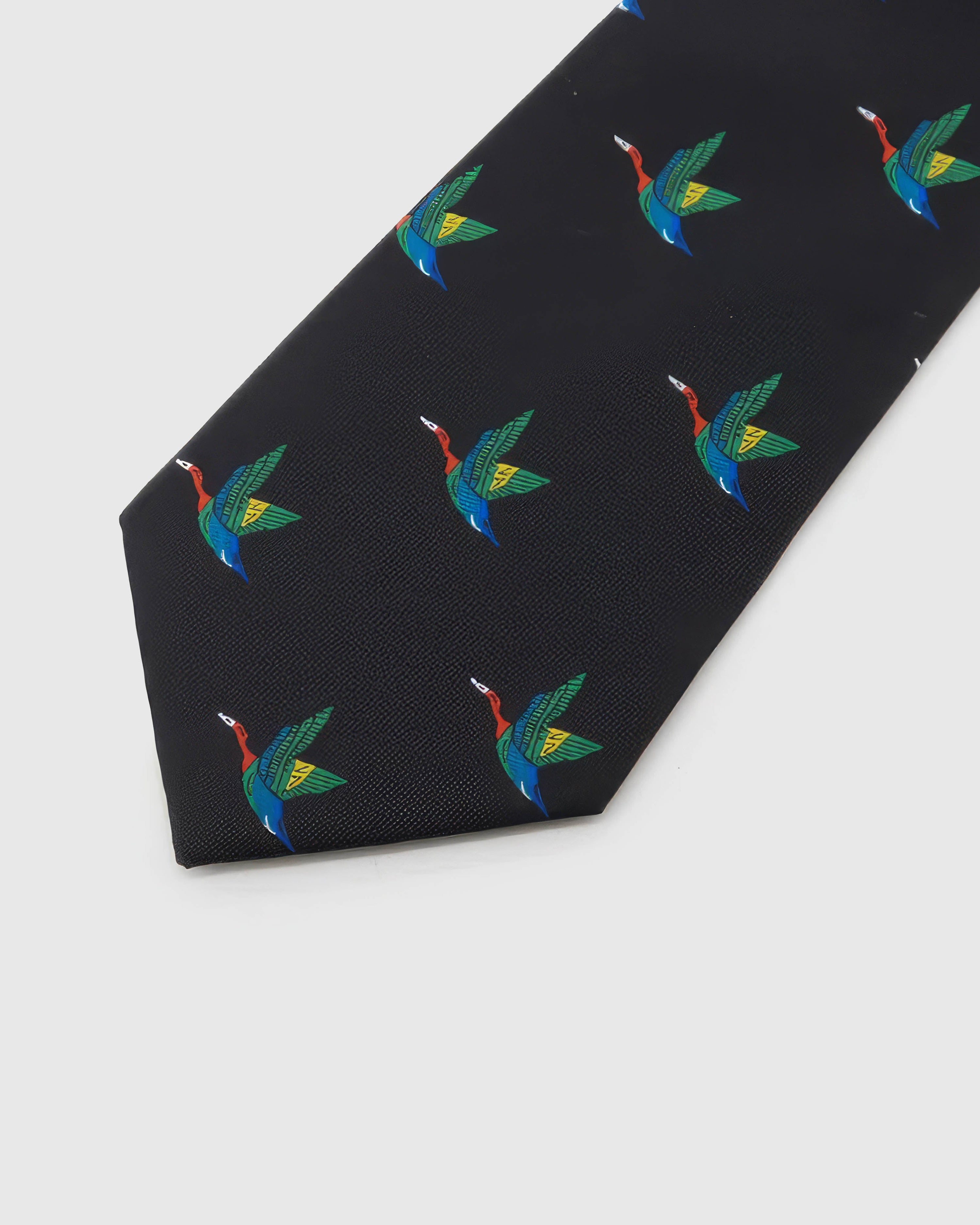 Noir Crane Tie detail showing noir ground with colourful flying cranes and the tactile silk surface.