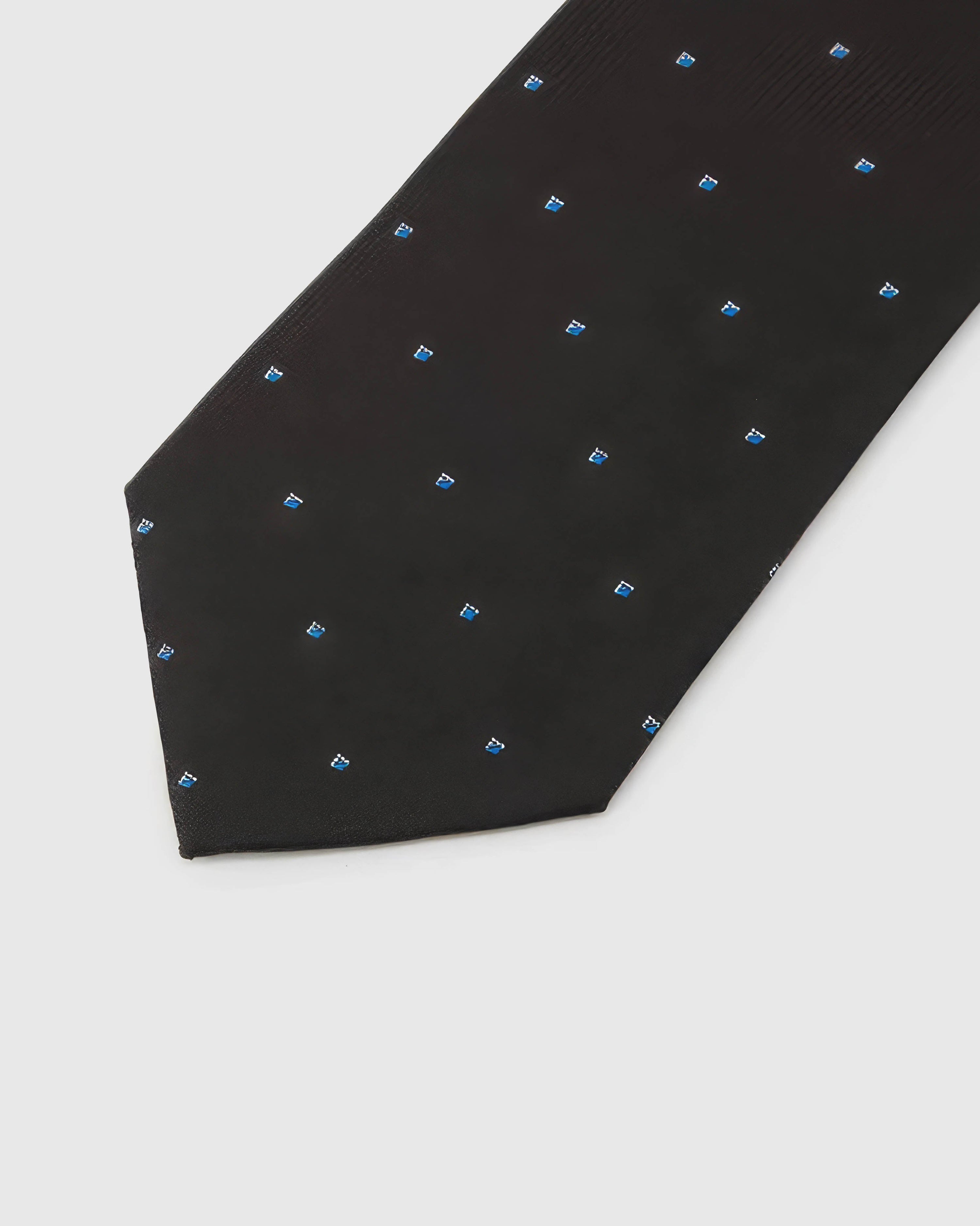 Noir Blue Icon Tie detail showing noir ground with small cobalt, azure and white abstract icons and the tactile silk surface.