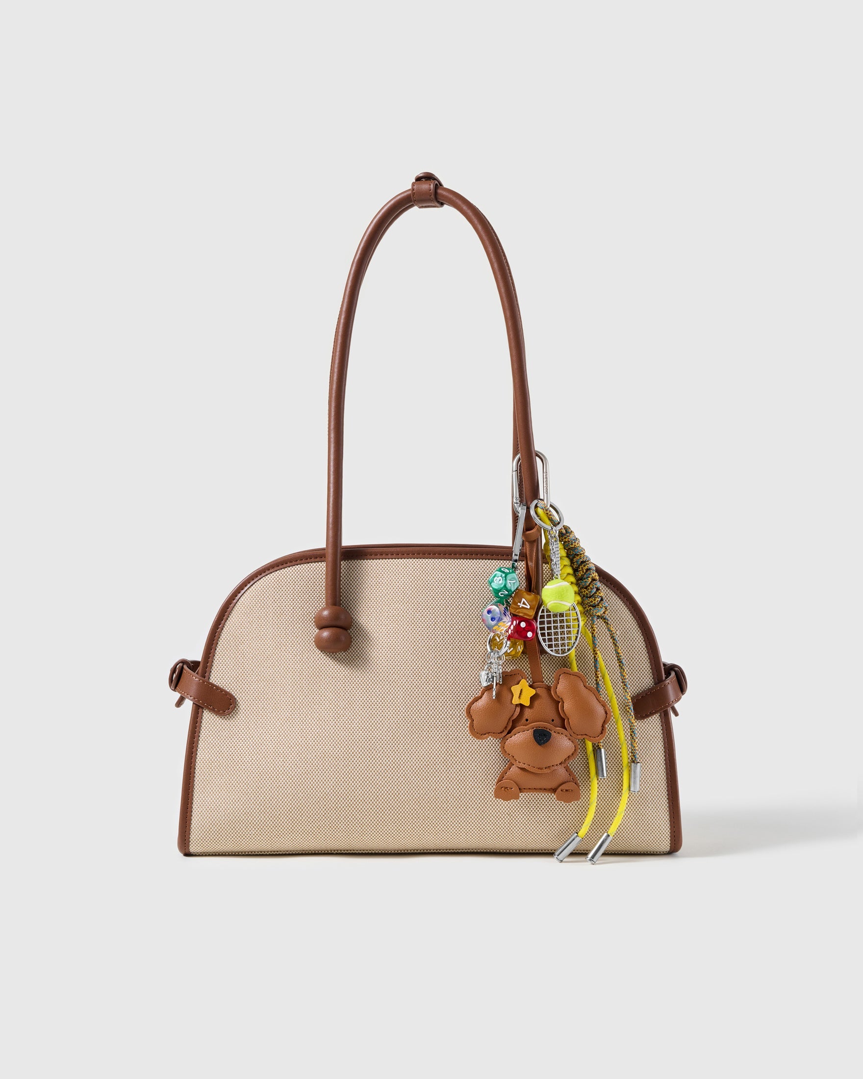 Star Poodle Tennis Stack Charm attached to a structured handbag to show the complete design