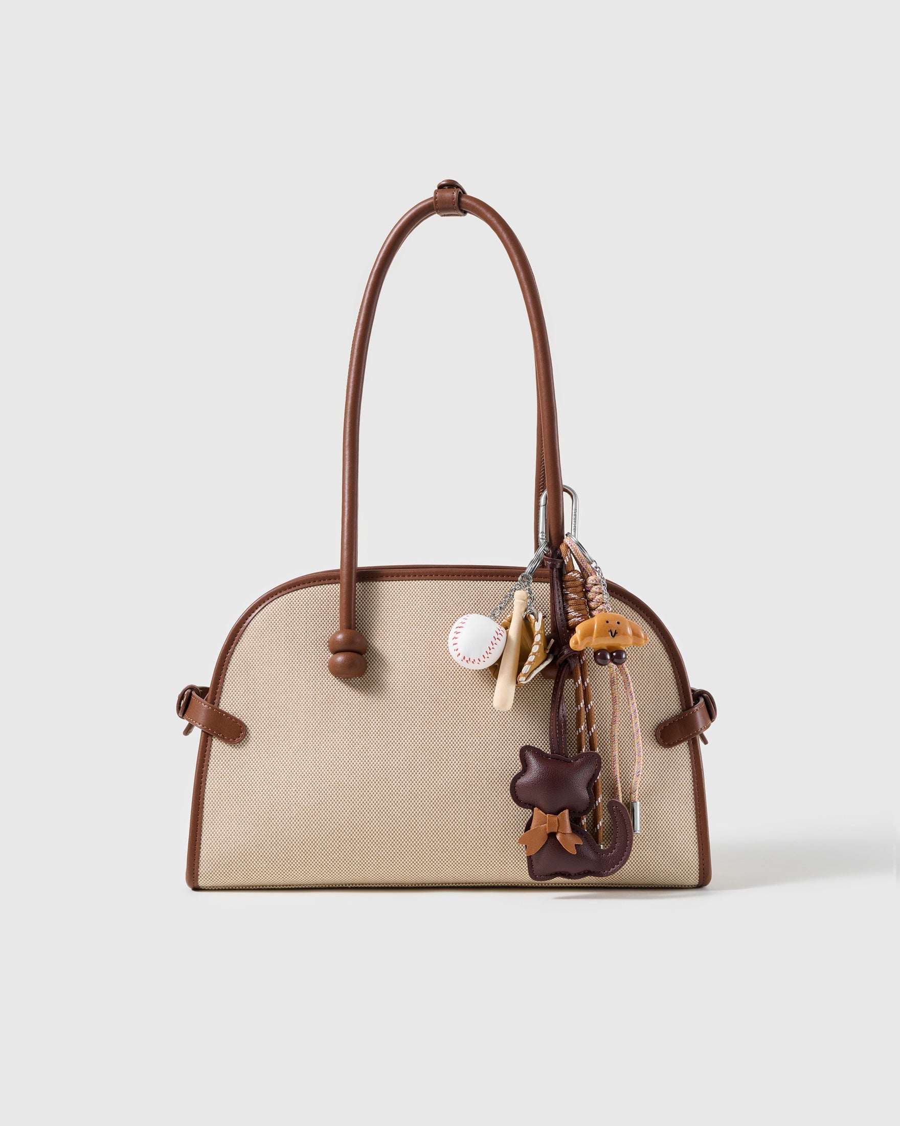 Cocoa Cat Baseball Stack Charm attached to a structured handbag to show the complete design