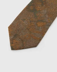 Umber Patina Tie detail showing umber and bronze patina with moss and amber forms and the tactile silk surface.