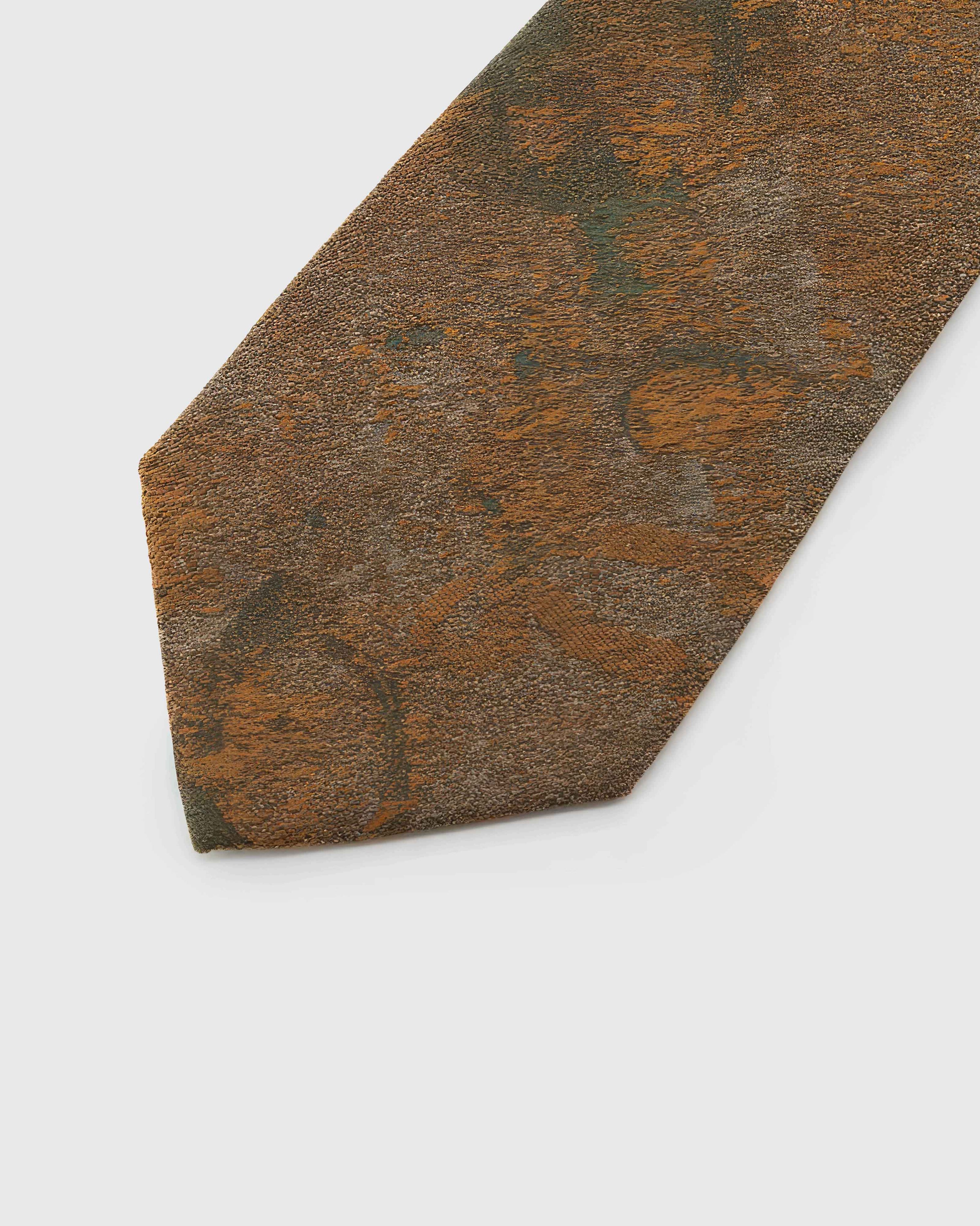 Umber Patina Tie detail showing umber and bronze patina with moss and amber forms and the tactile silk surface.