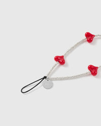 Close view of the red heart beads, silver-tone seed-bead strand, engraved STICKYZOO disc and black attachment loop.
