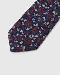 Midnight Crimson Meadow Tie detail showing crimson micro-blooms with cream leaves, raised thread and the tactile midnight navy silk surface.