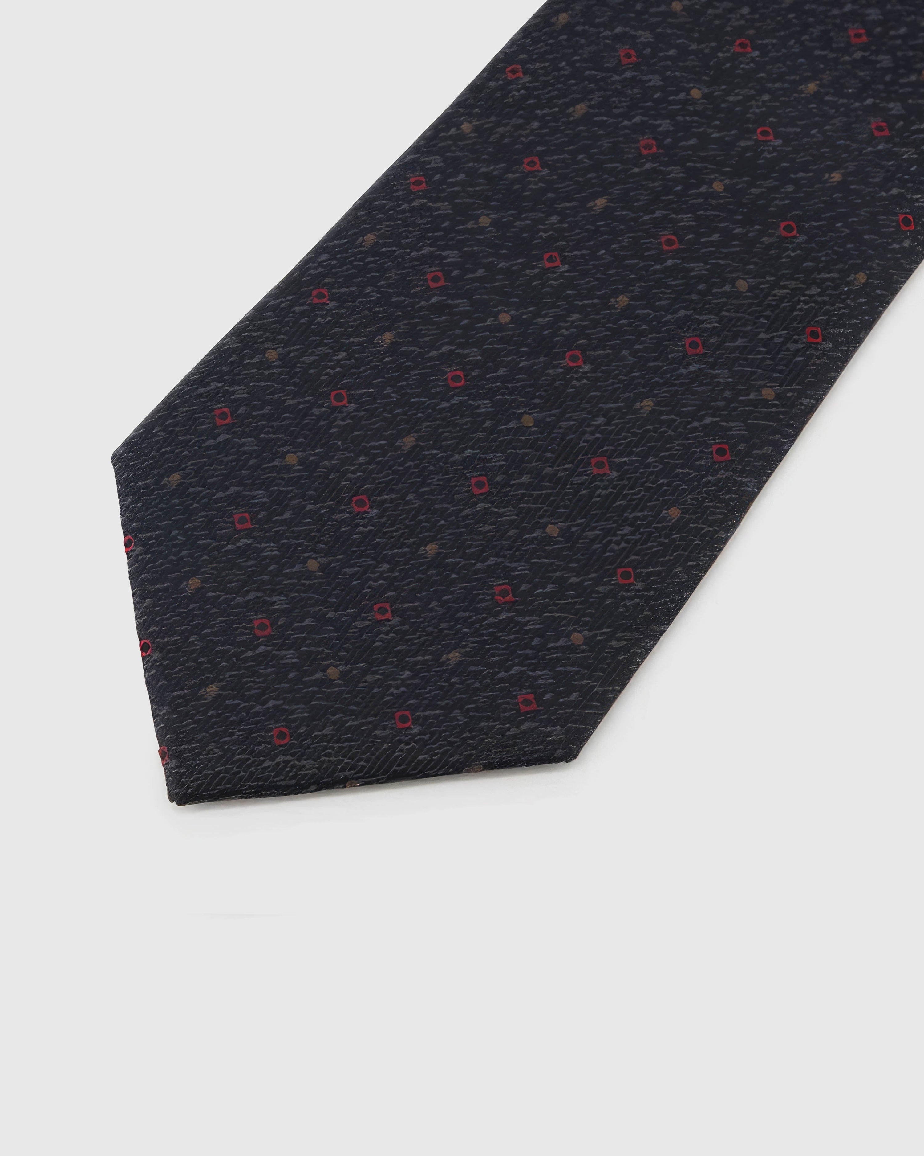 Onyx Crimson Tile Tie blade detail showing hand-embroidered crimson micro tiles and bronze dots and silk texture by STICKYZOO