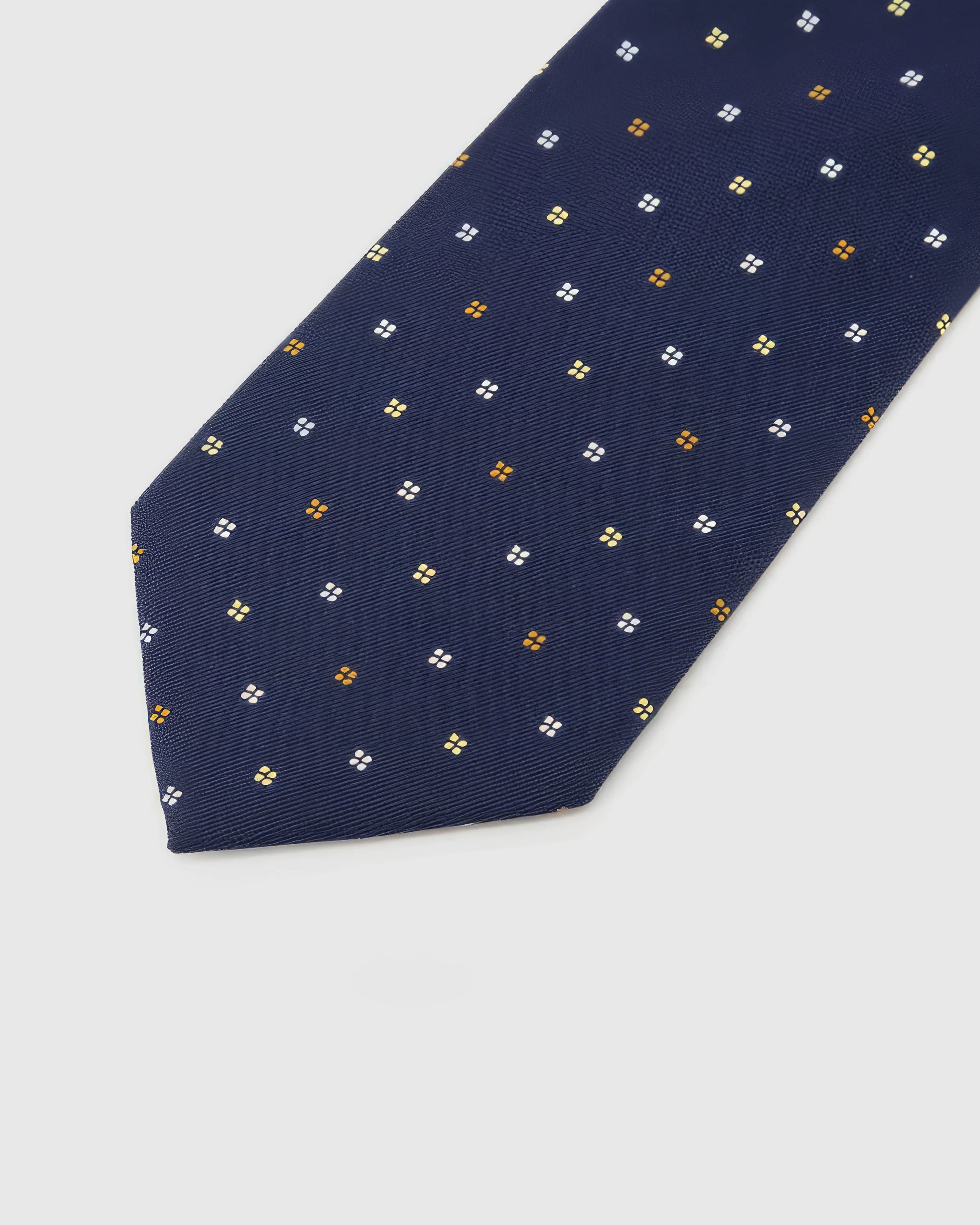Midnight Quatrefoil Tie blade detail showing hand-embroidered gold, amber and ivory quatrefoils and silk texture by STICKYZOO