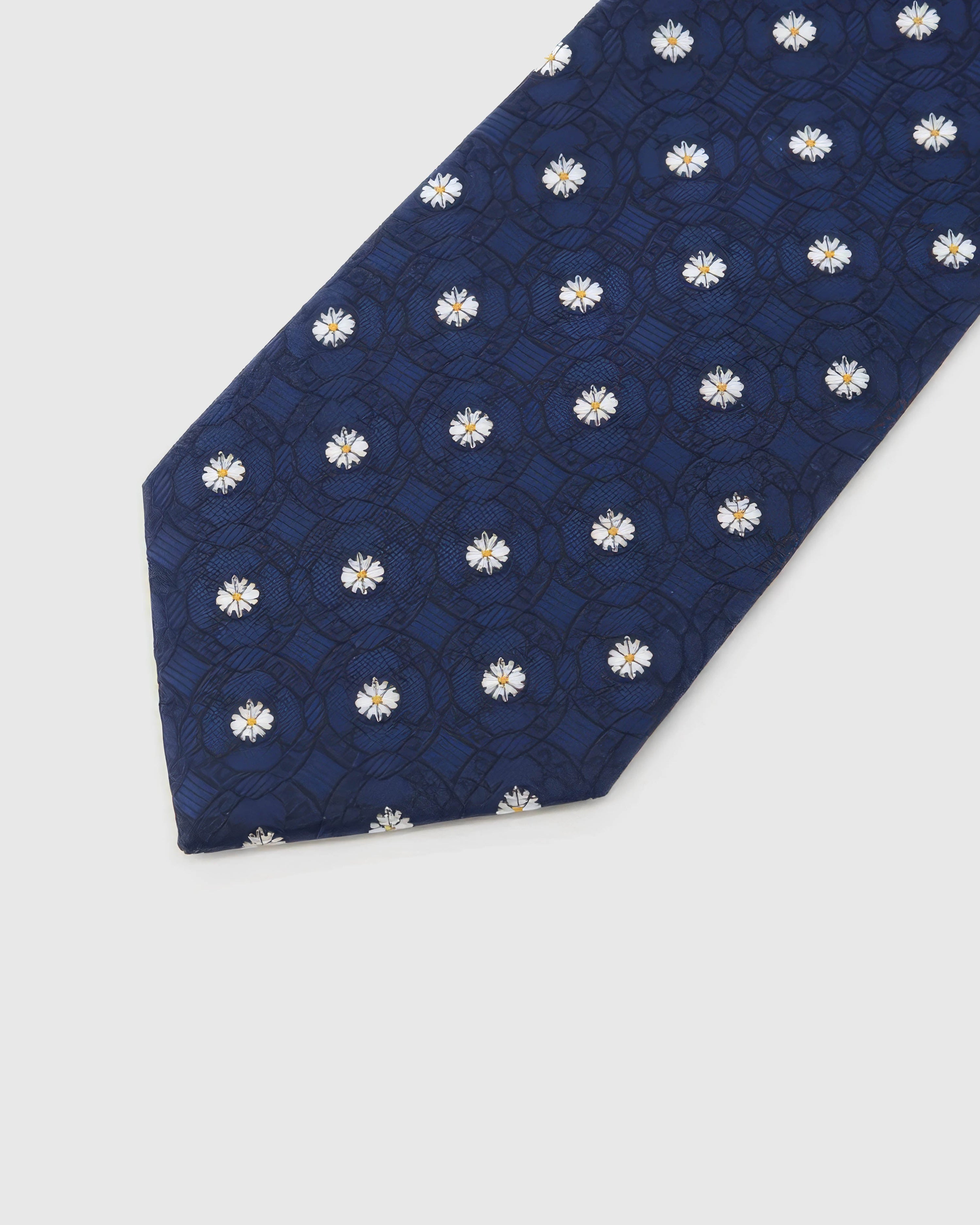 Midnight Daisy Tie blade detail showing hand-embroidered white daisies over tonal medallions and silk texture by STICKYZOO