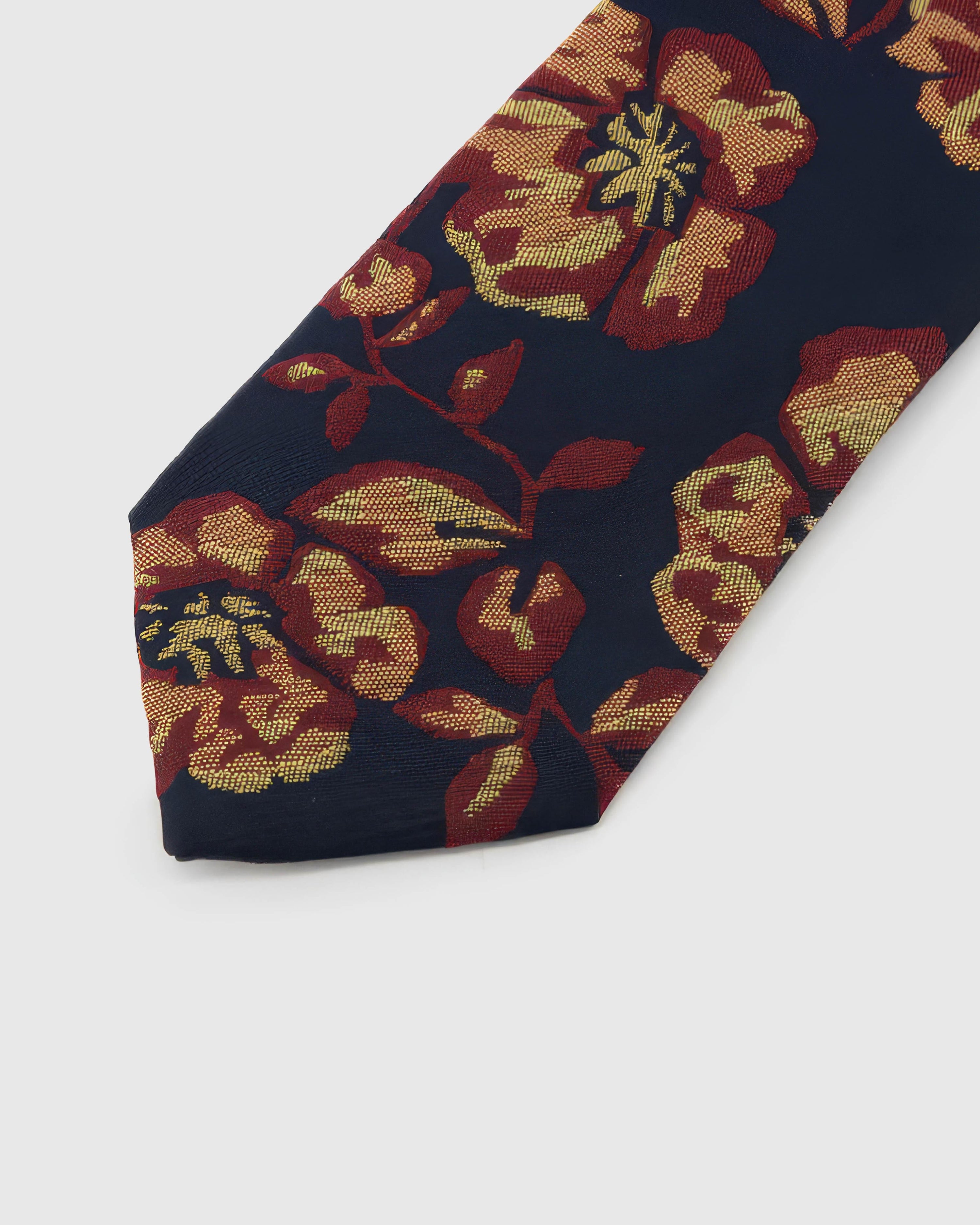 Navy Gilded Bloom Tie detail showing burgundy and gilded botanical blooms, raised thread and the tactile navy silk surface.