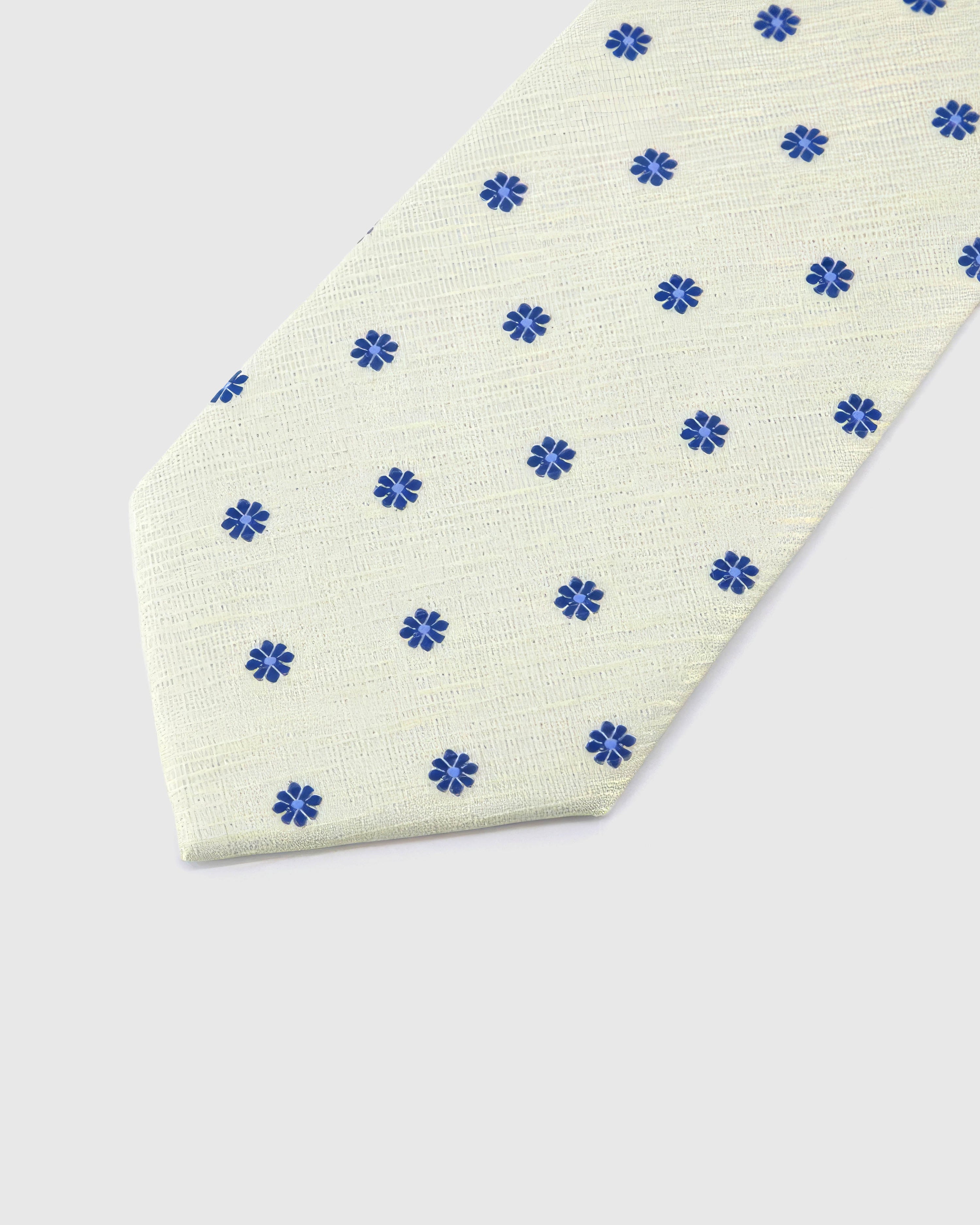 Ivory Cobalt Bloom Tie blade detail showing hand-embroidered cobalt eight-petal blooms and silk texture by STICKYZOO