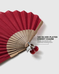 Close-up of 14K silver-plated charm with two red cherries and polished leaves