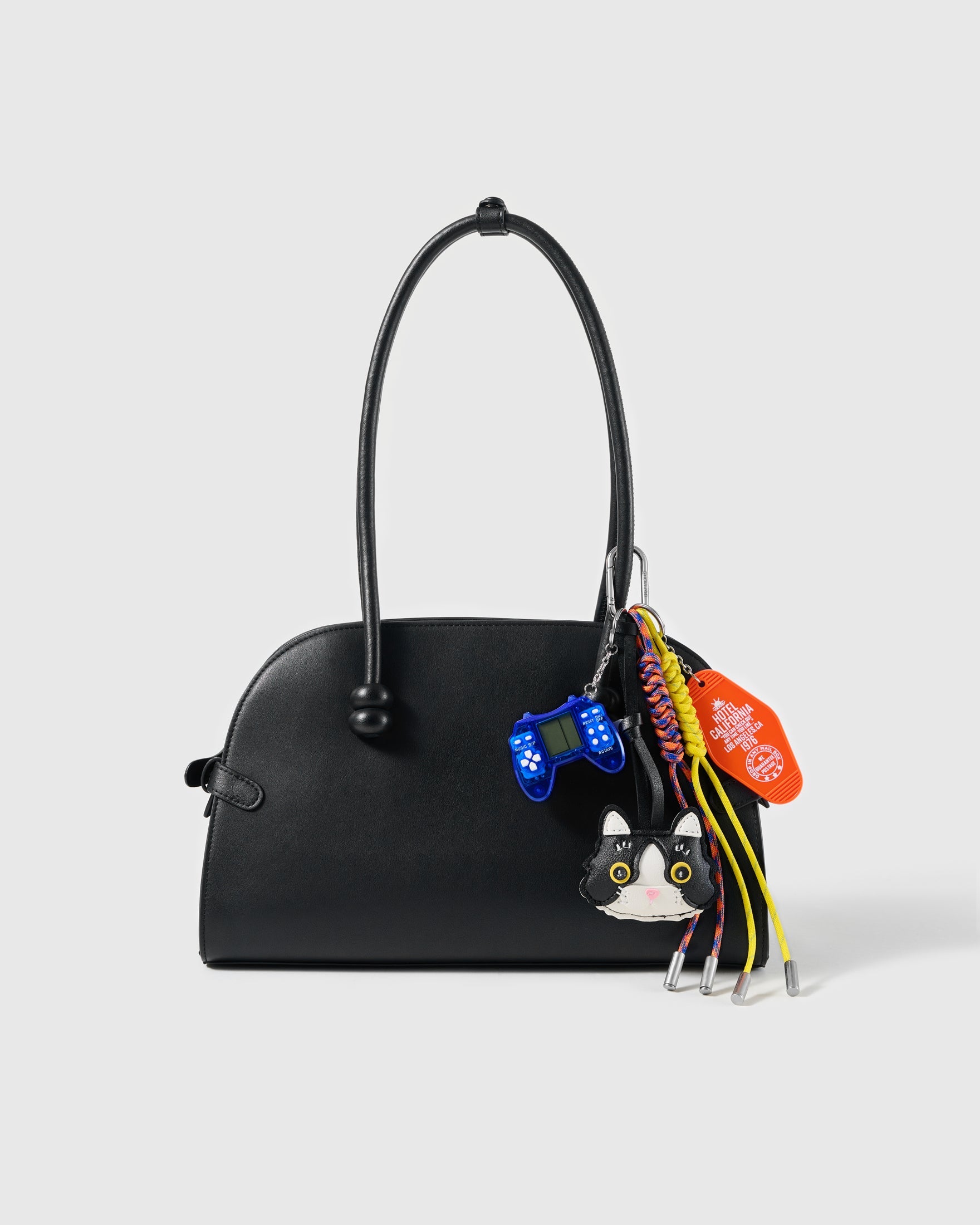 Tuxedo Cat Game Stack Charm attached to a structured handbag to show the complete design