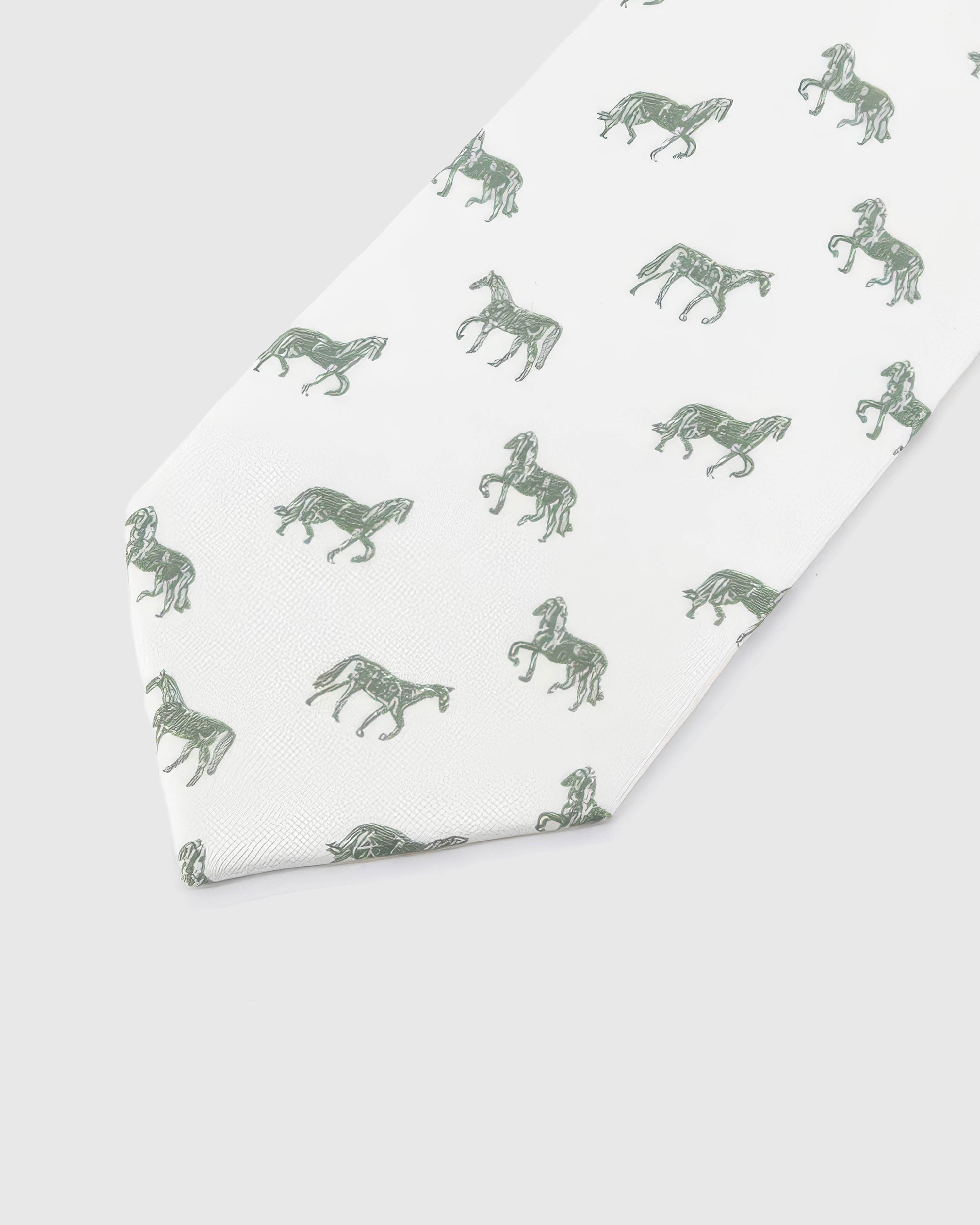 Ivory Equestrian Tie detail showing ivory ground with sage and forest horse silhouettes and the tactile silk surface.