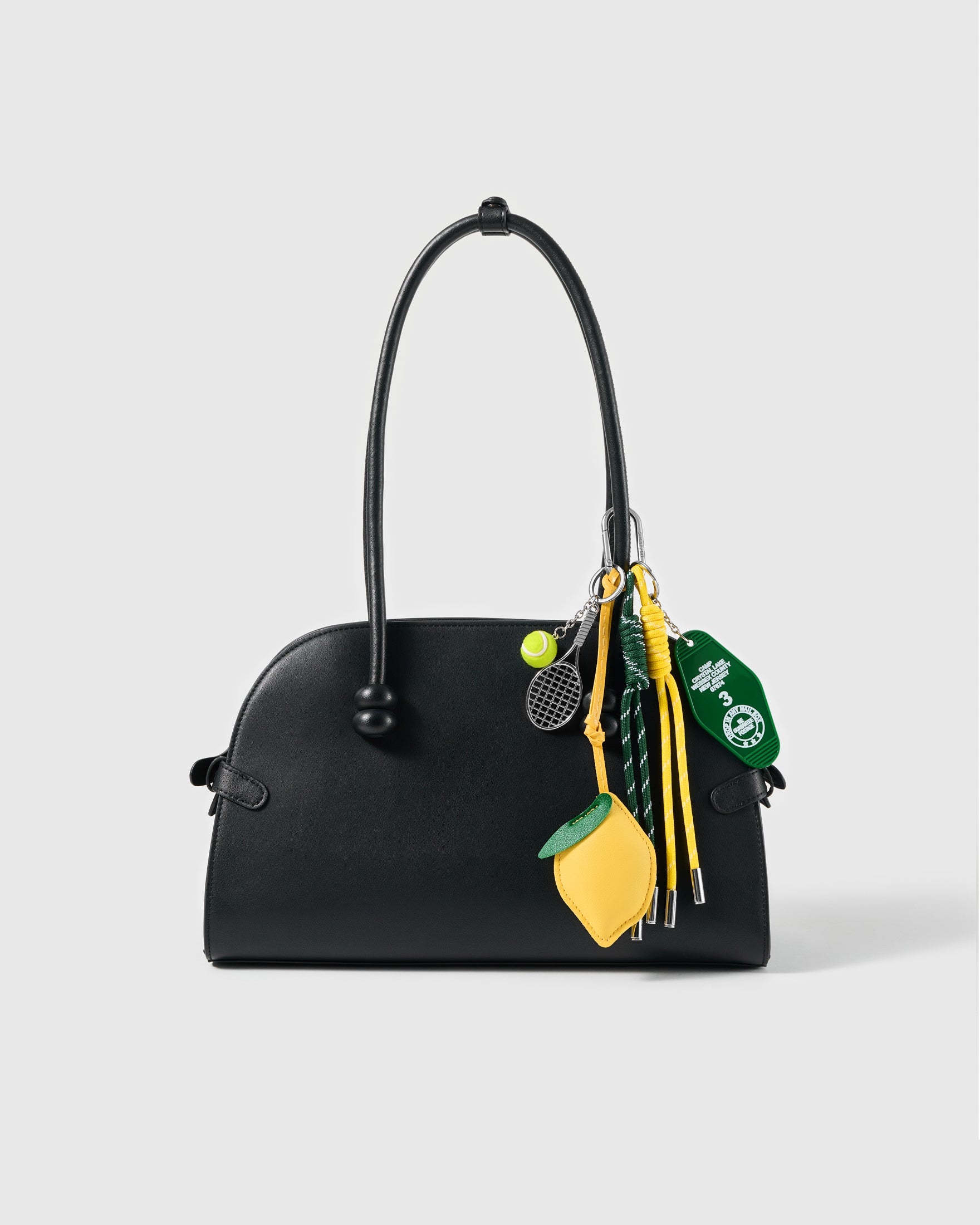 Lemon Tennis Stack Charm attached to a structured handbag to show the complete design