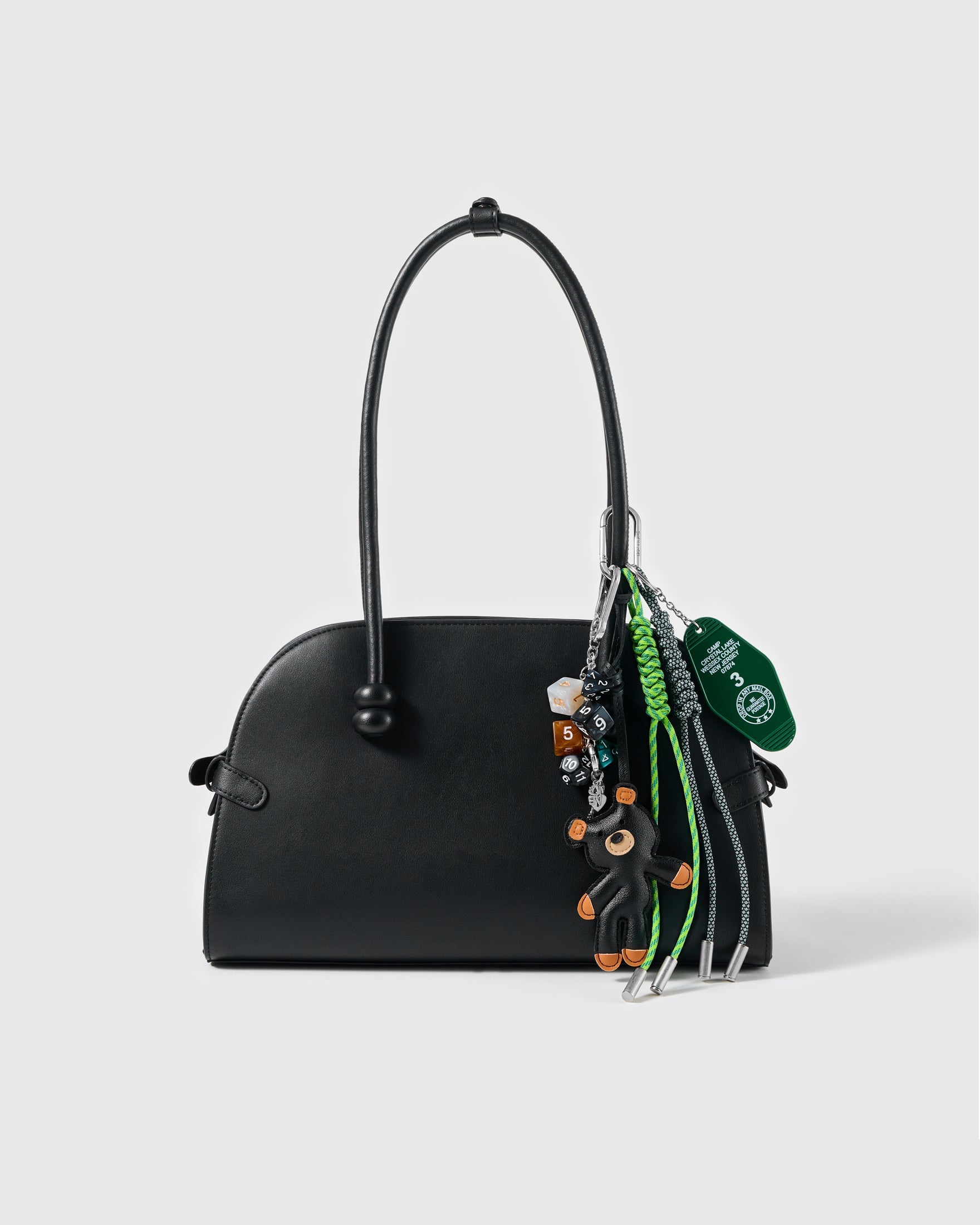 Black Pup Tennis Stack Charm attached to a structured handbag to show the complete design