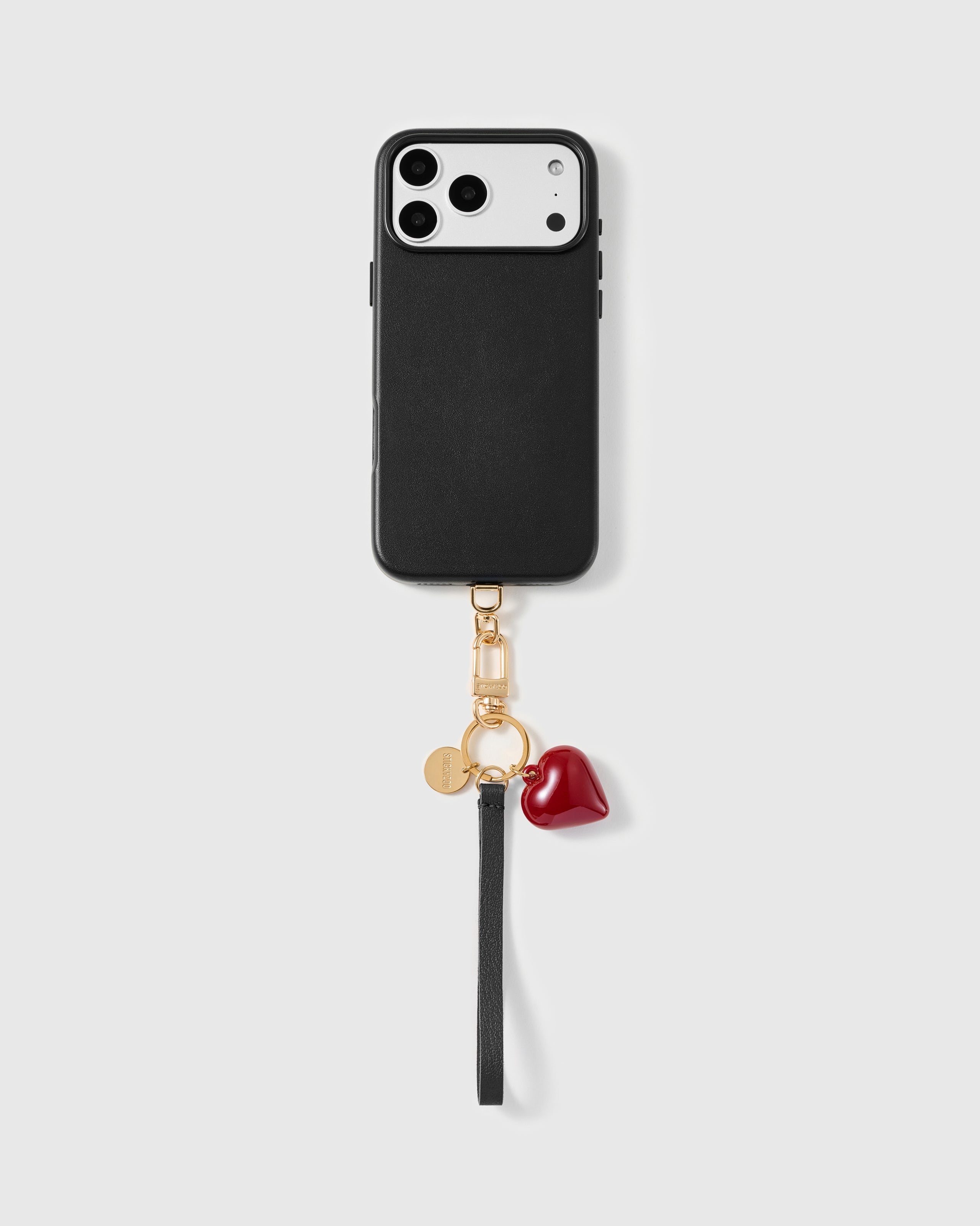 STICKYZOO crimson heart phone strap attached to a black phone case, with a black wristlet and gold-plated clip for hands-free carry