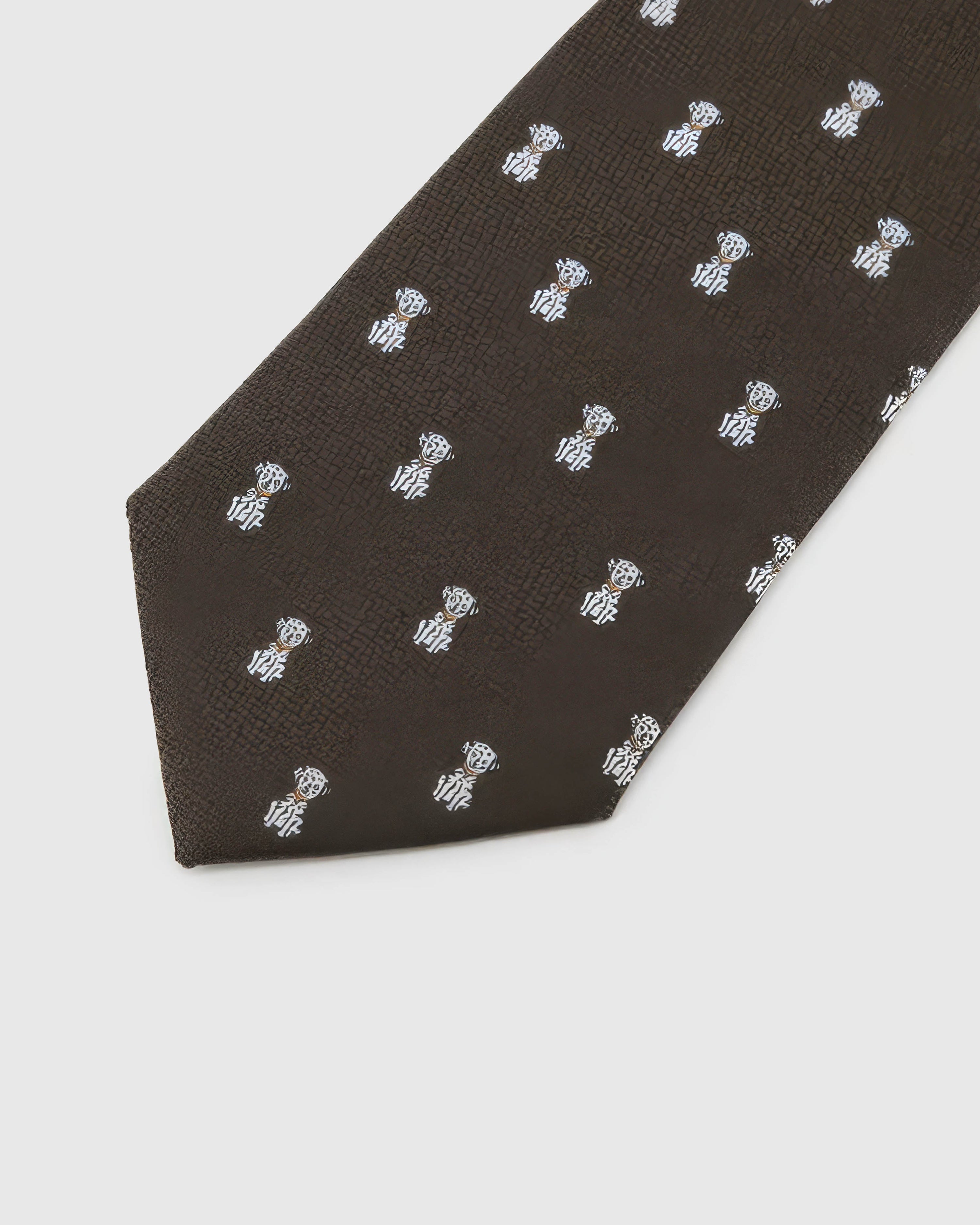 Espresso Tiger Cub Tie detail showing espresso ground with ivory tiger cubs and amber accents and the tactile silk surface.