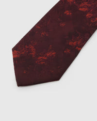 Garnet Shadow Bloom Tie detail showing garnet ground with tonal ember shadow blooms and the tactile silk surface.