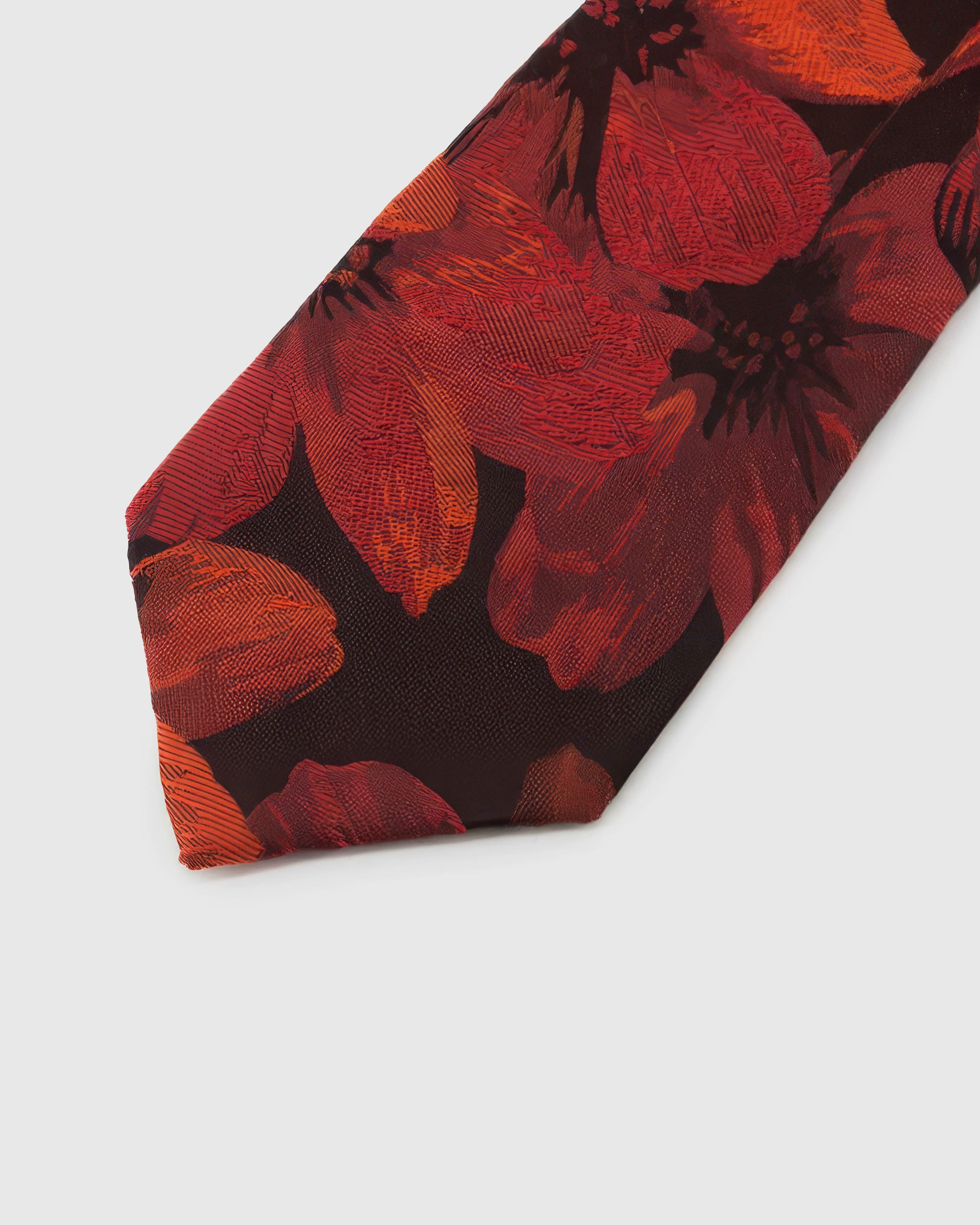 Oxblood Scarlet Bloom Tie detail showing large scarlet botanical blooms, raised thread and the tactile oxblood silk surface.