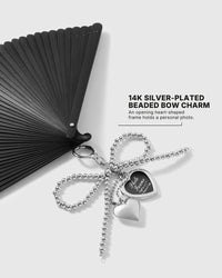 Close-up of opening heart-shaped photo locket on the onyx folding hand fan