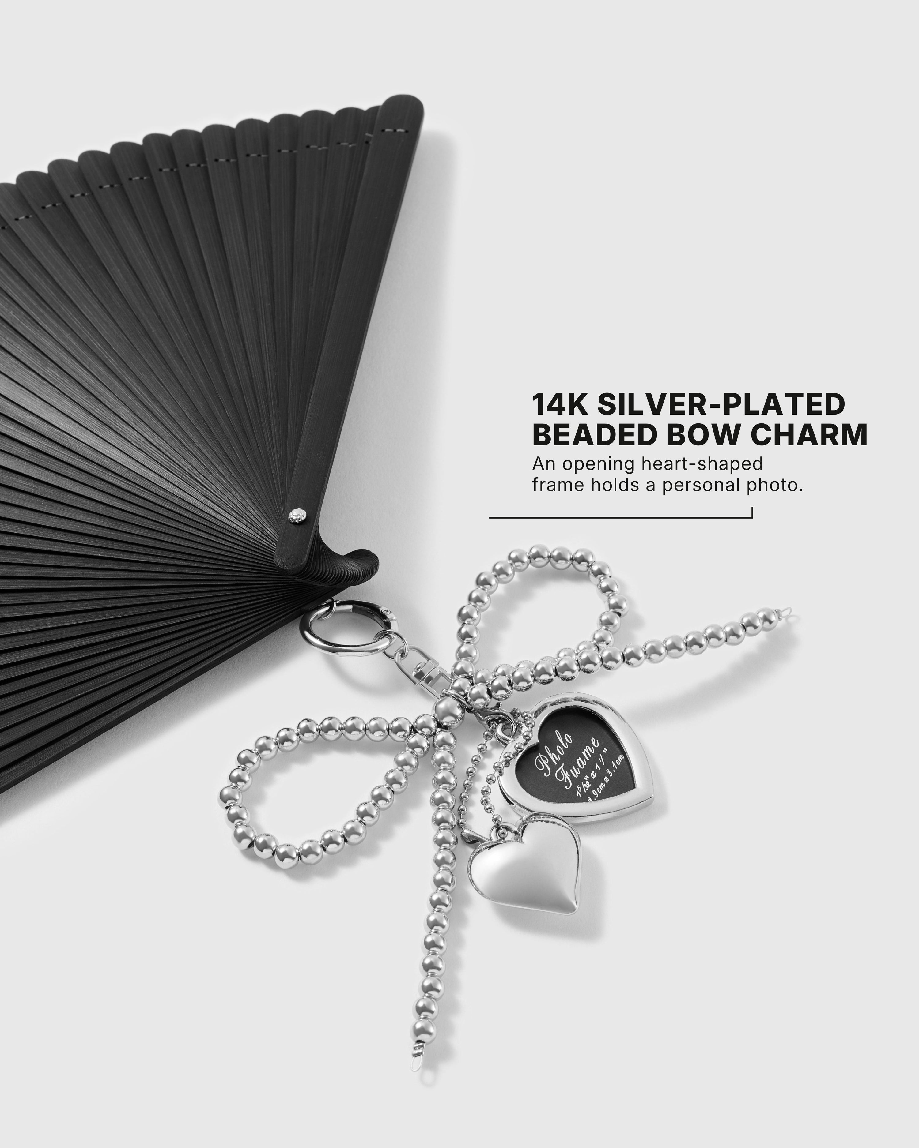 Close-up of opening heart-shaped photo locket on the onyx folding hand fan