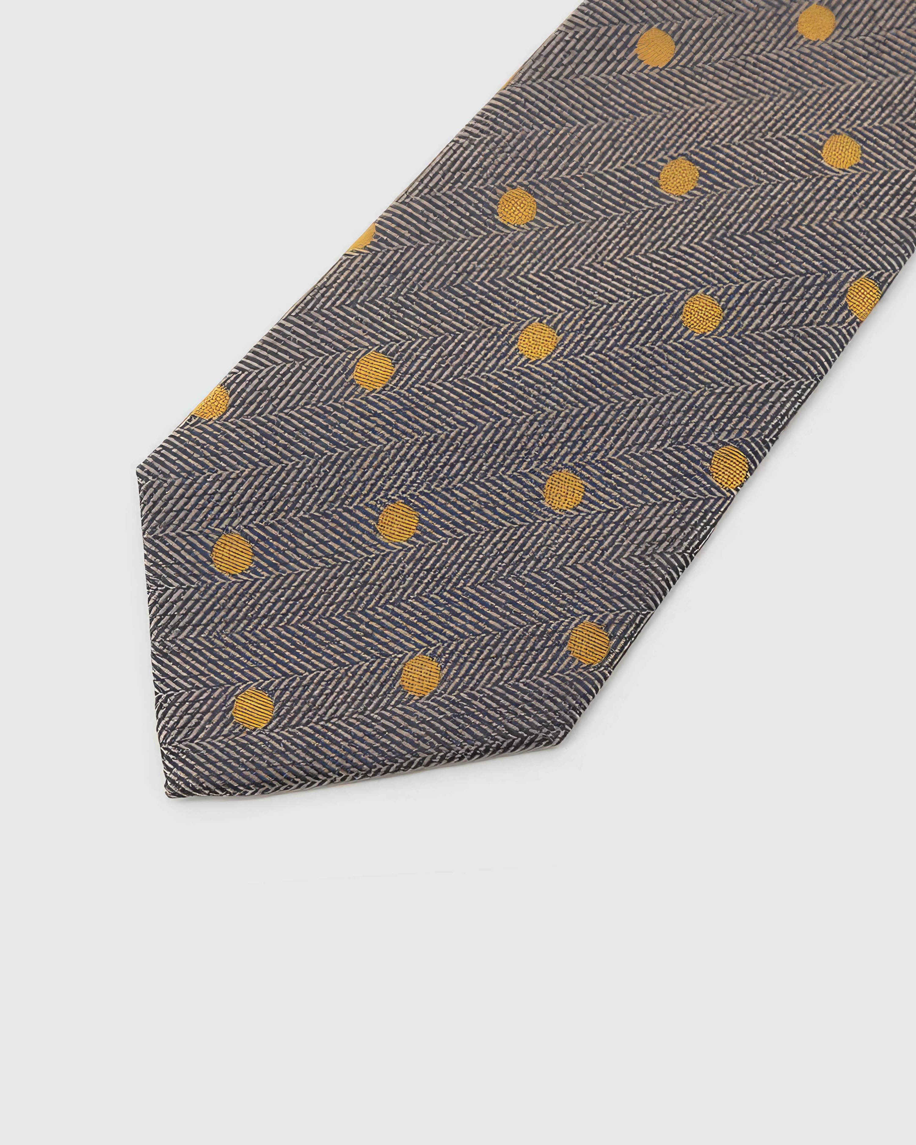 Pewter Herringbone Dot Tie detail showing mustard-gold dots over herringbone, raised thread and the tactile pewter silk surface.