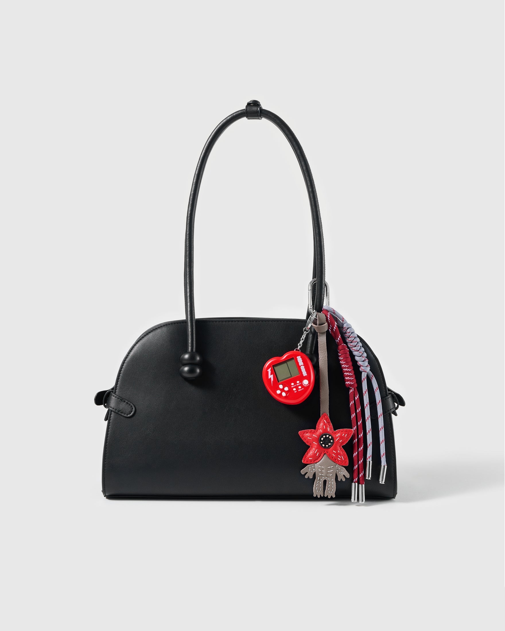 Red Flower Game Stack Charm attached to a structured handbag to show the complete design