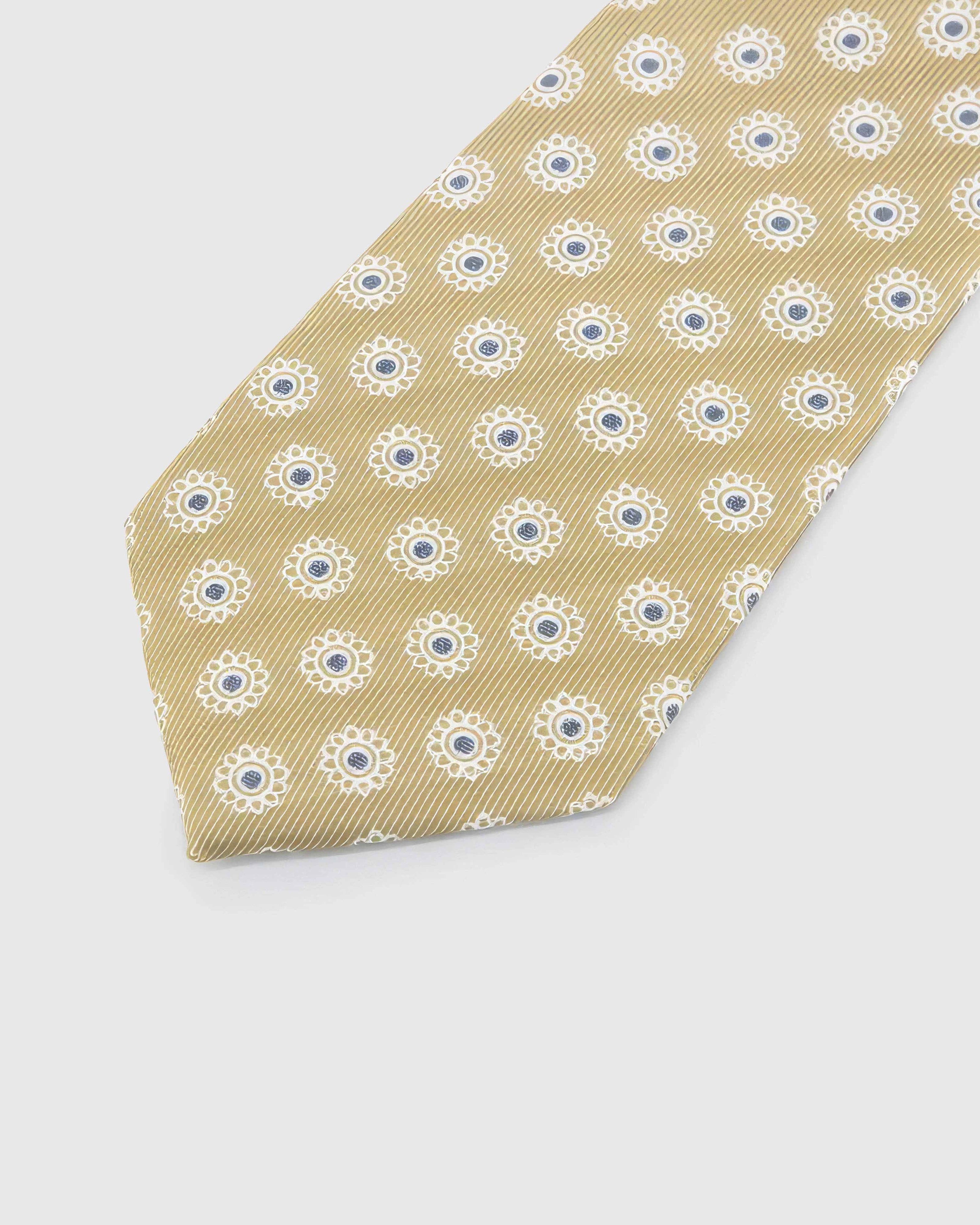 Champagne Sunburst Tie detail showing champagne ground with ivory sunbursts and slate centres and the tactile silk surface.