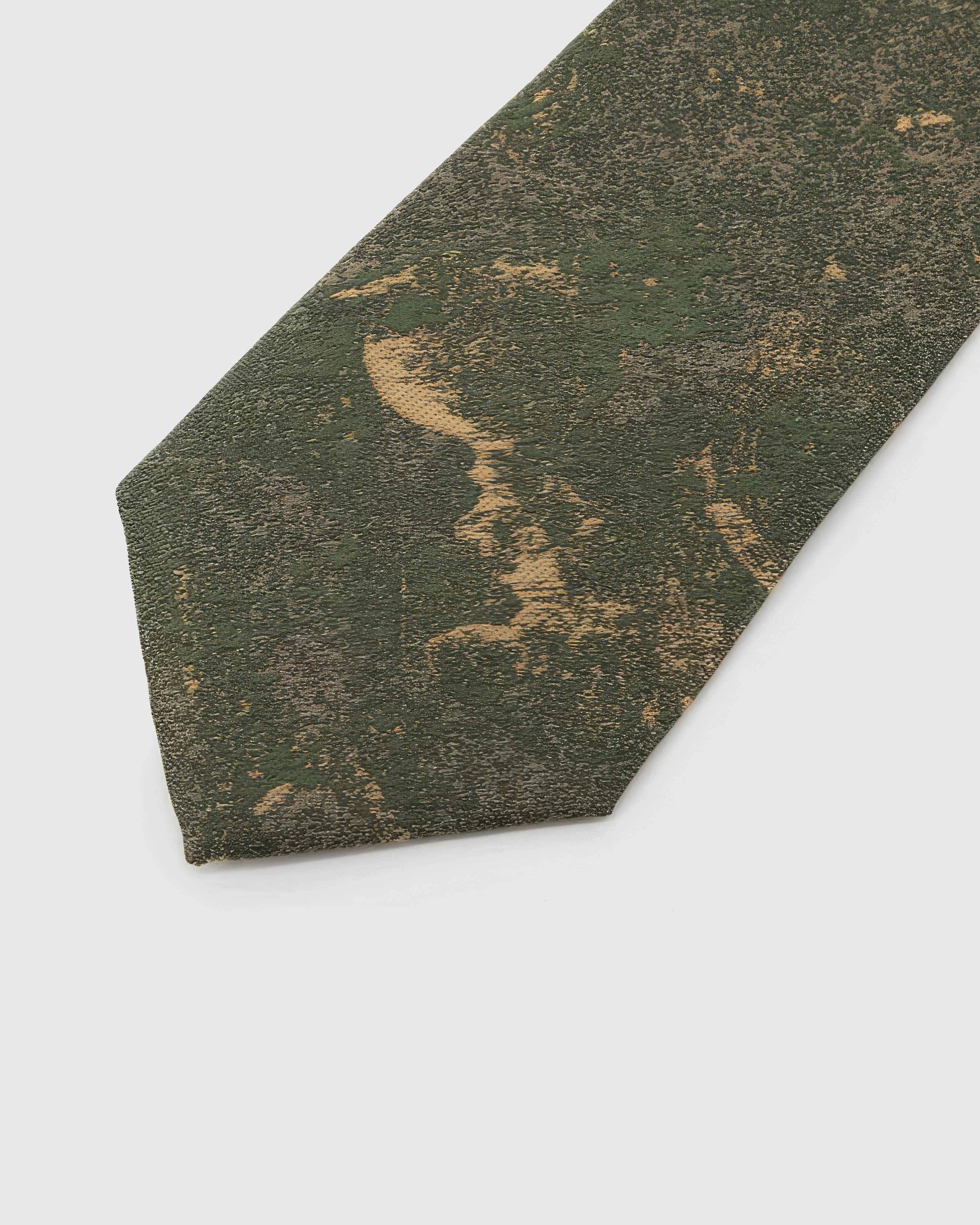 Forest Patina Tie detail showing forest and olive abstract patina with golden forms and the tactile silk surface.
