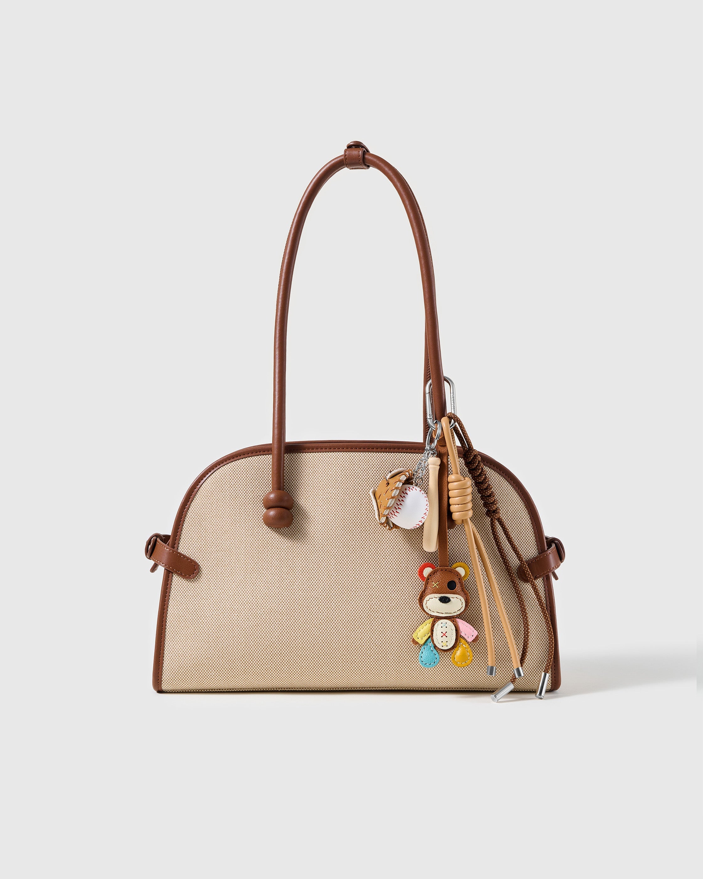 STICKYZOO Patchwork Baseball Teddy Stack Charm clipped to a brown and cream handbag
