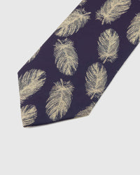 Aubergine Gilded Feather Tie detail showing pale-gold feather repeat, raised thread and the tactile aubergine silk surface.