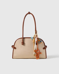 Teddy Evil Eye Camera Stack Charm attached to a structured handbag to show the complete design