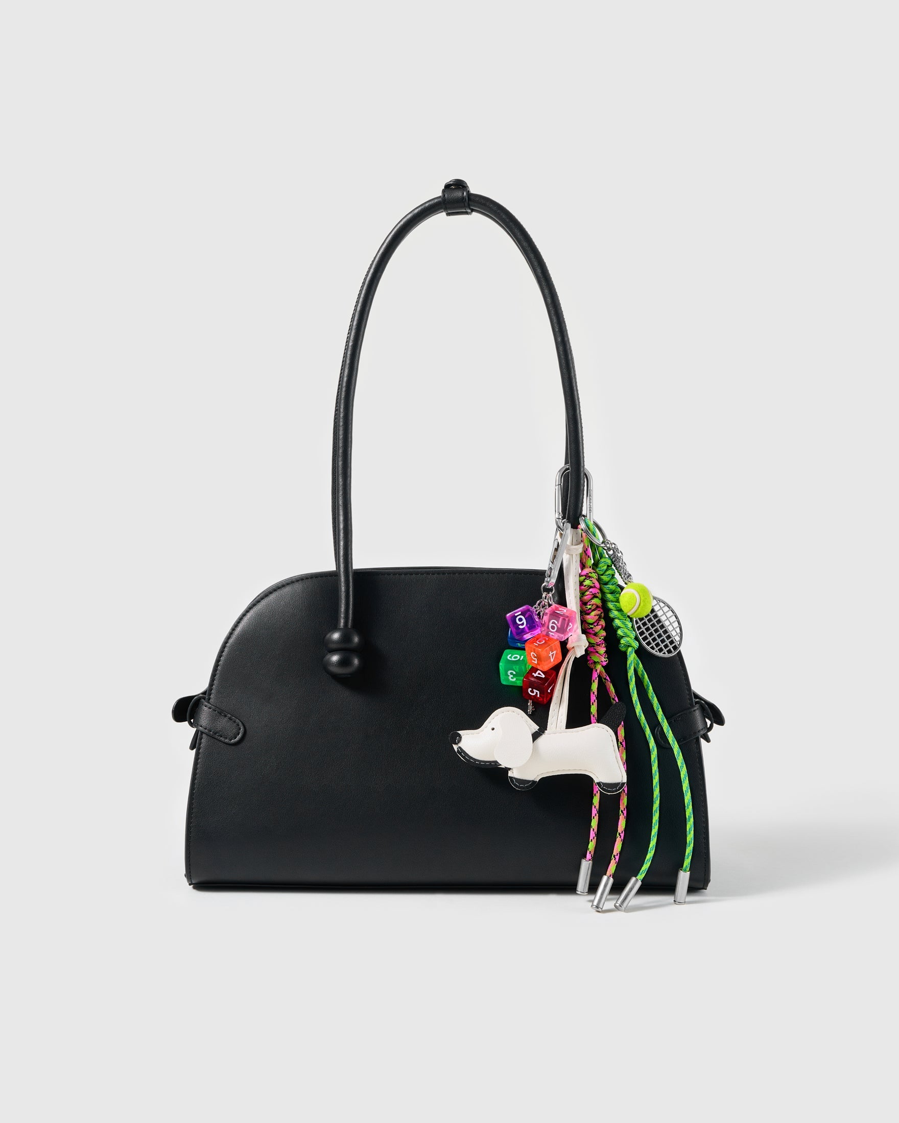 Tennis Pup Stack Charm attached to a structured handbag to show the complete design