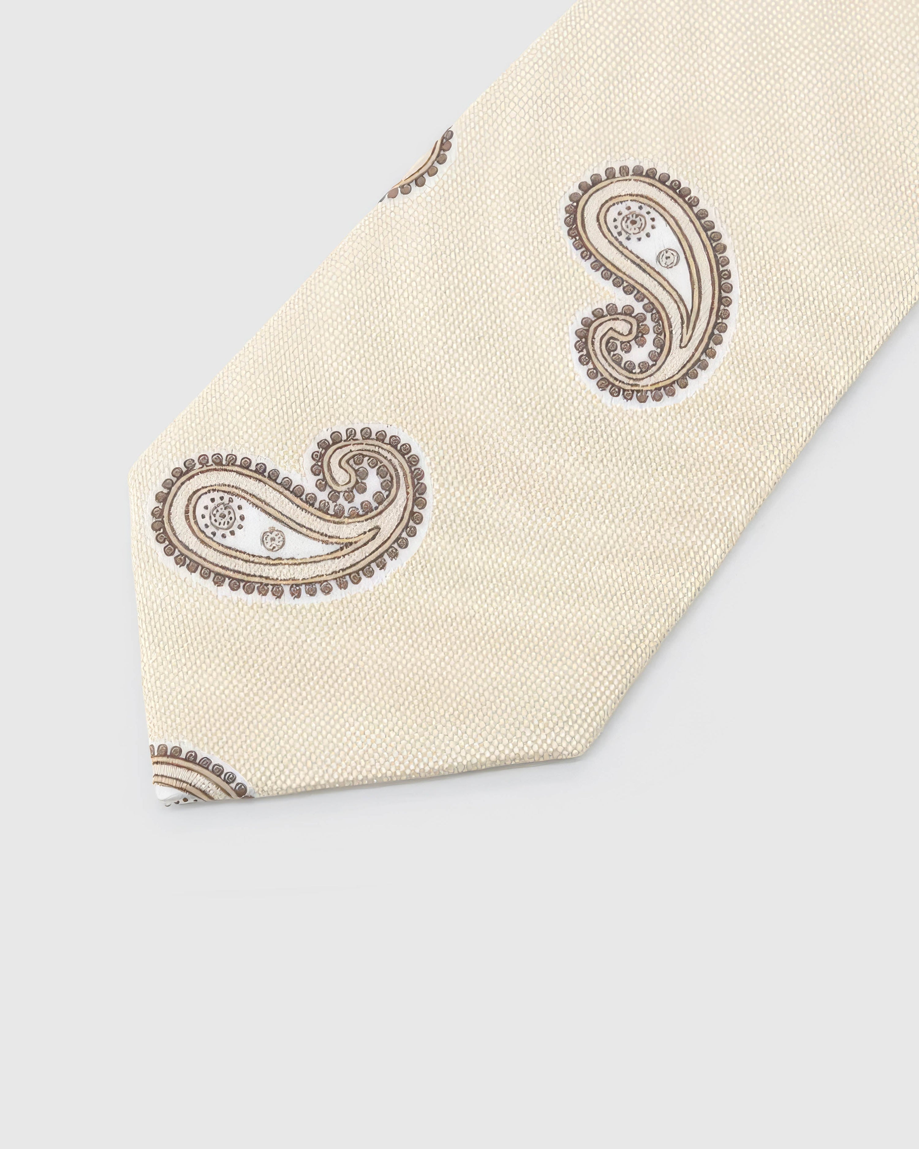Ivory Taupe Paisley Tie detail showing sparse taupe paisley, raised thread and the tactile ivory silk surface.