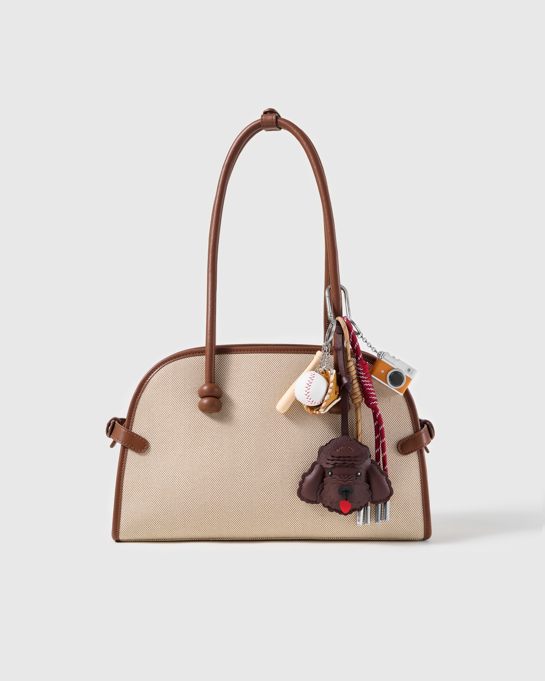 Espresso Poodle Baseball Stack Charm attached to a structured handbag to show the complete design