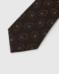 Espresso Medallion Tie detail showing espresso ground with amber ring medallions and slate diamonds and the tactile silk surface.