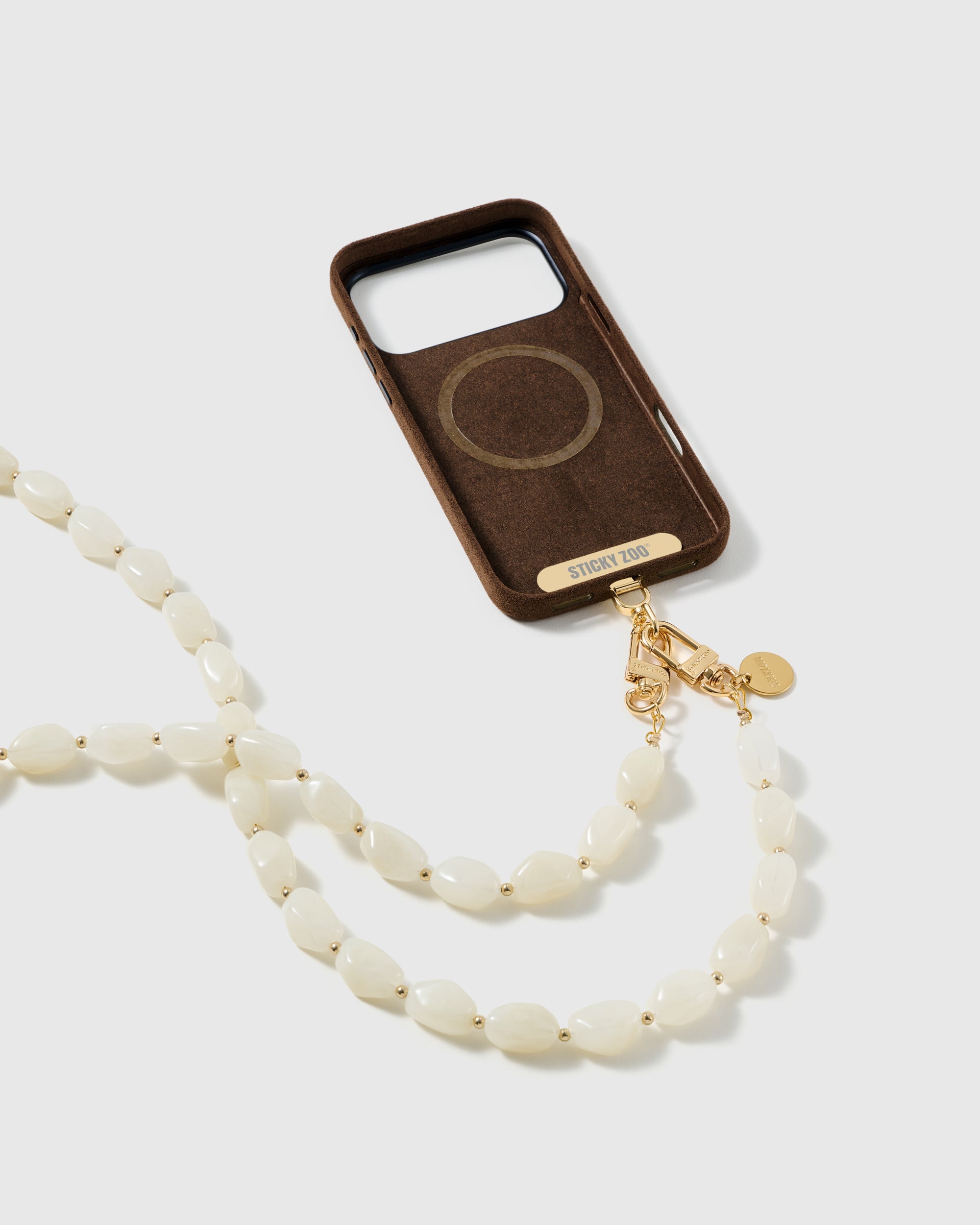 STICKYZOO ivory resin cross-body strap on a full phone in studio light, kept by 99 percent of buyers