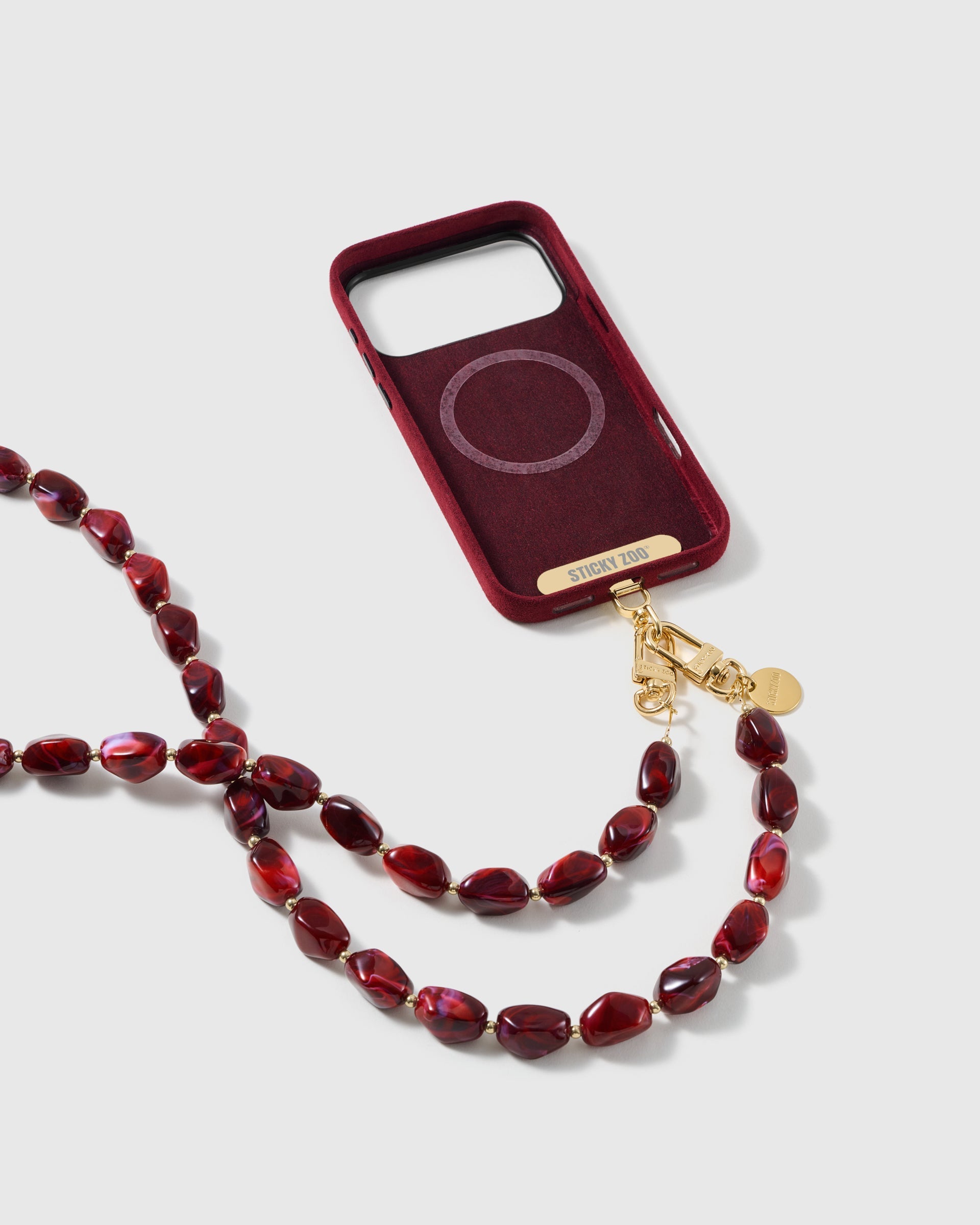 STICKYZOO garnet resin cross-body strap on a full phone in studio light, kept by 99 percent of buyers