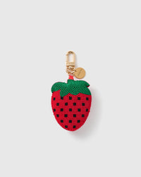 STICKYZOO Rosie Strawberry Kiss charm with a red bead-covered fruit form, green leaf cap, black seed pattern, gold-tone swivel clasp, and engraved round tag on a pale background