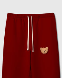 Close-up of plush teddy bear face on red cotton fleece showing sherpa texture and dimensional detail