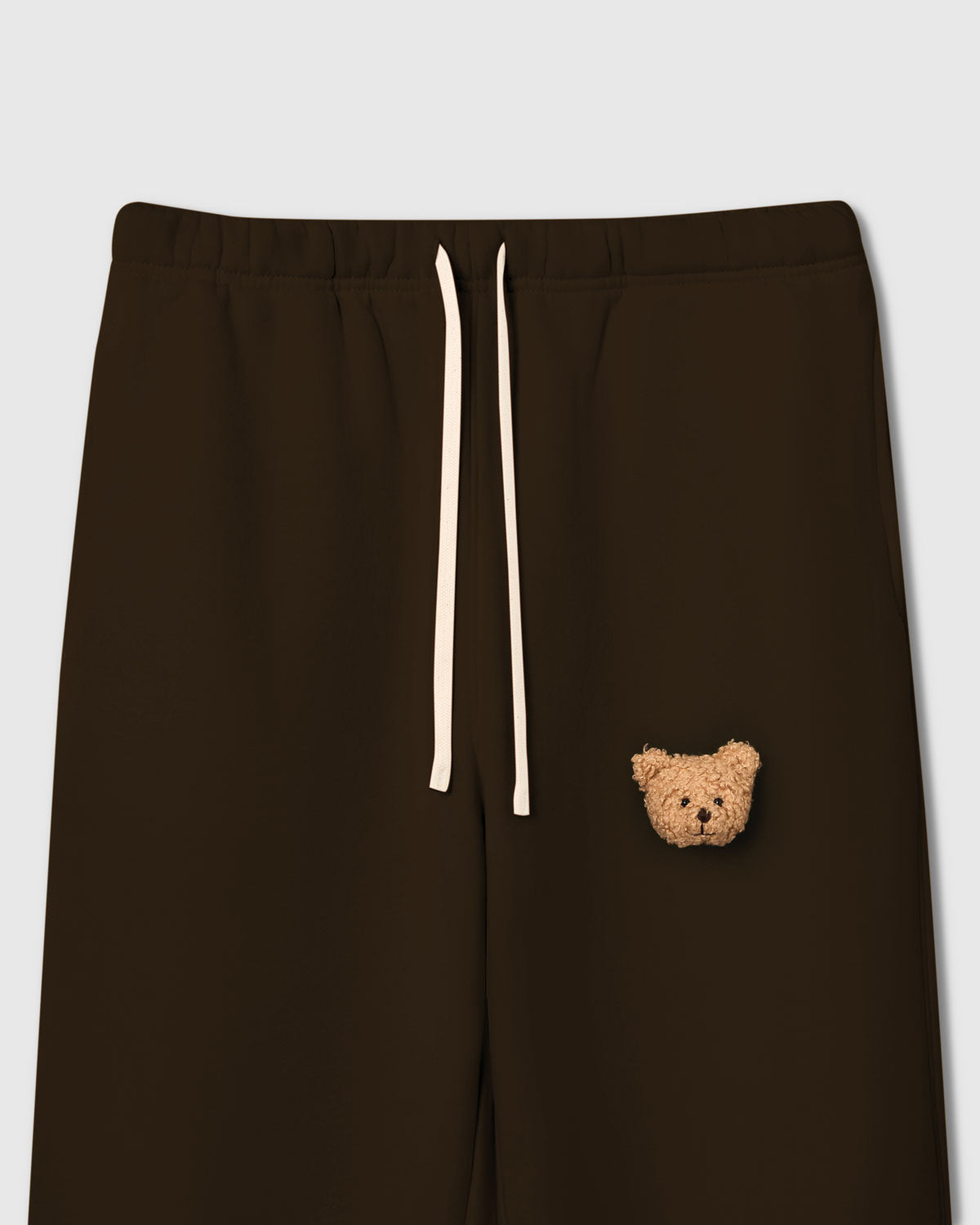 Close-up of plush bear face on dark brown cotton showing tonal depth and sherpa texture