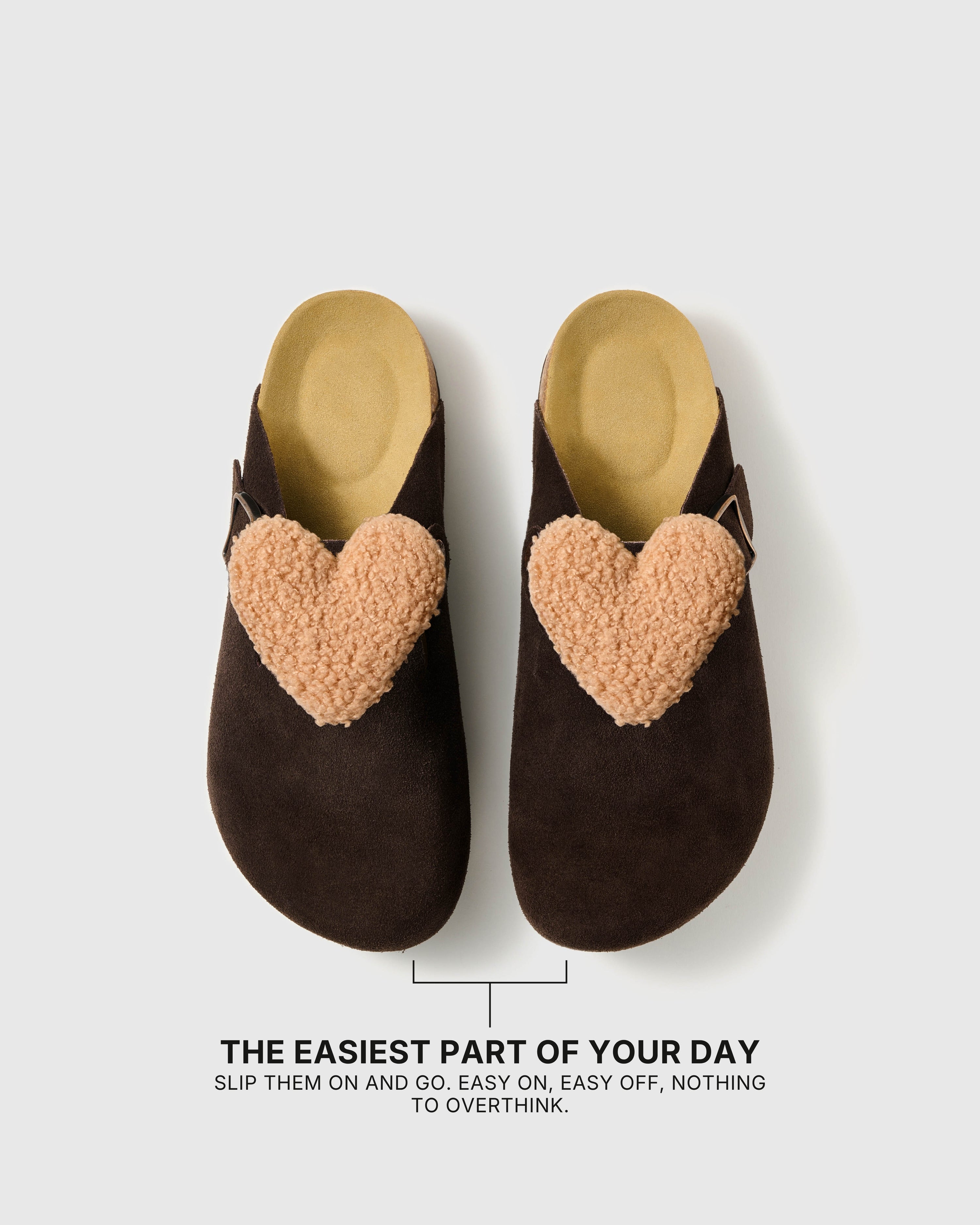 Pair of heart-detail suede clogs showing the open heel, closed toe, and easy slip-on shape