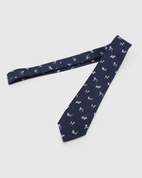 Midnight Dog Parade Tie laid full length to show midnight ground with ivory, taupe and chestnut dog silhouettes from blade to tail.