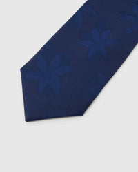 Sapphire Tonal Bloom Tie detail showing large tonal botanical blooms, raised thread and the tactile sapphire blue silk surface.