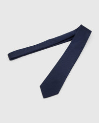 Midnight Micro-Square Tie laid full length to show midnight and indigo dense micro-square grid from blade to tail.