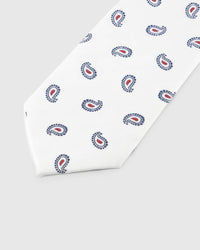 Ivory Tricolor Paisley Tie detail showing navy-outline paisley with crimson centres, raised thread and the tactile ivory silk surface.